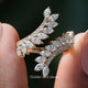 Marquise Cut Diamond Bypass Wedding Ring Held Between Fingers
