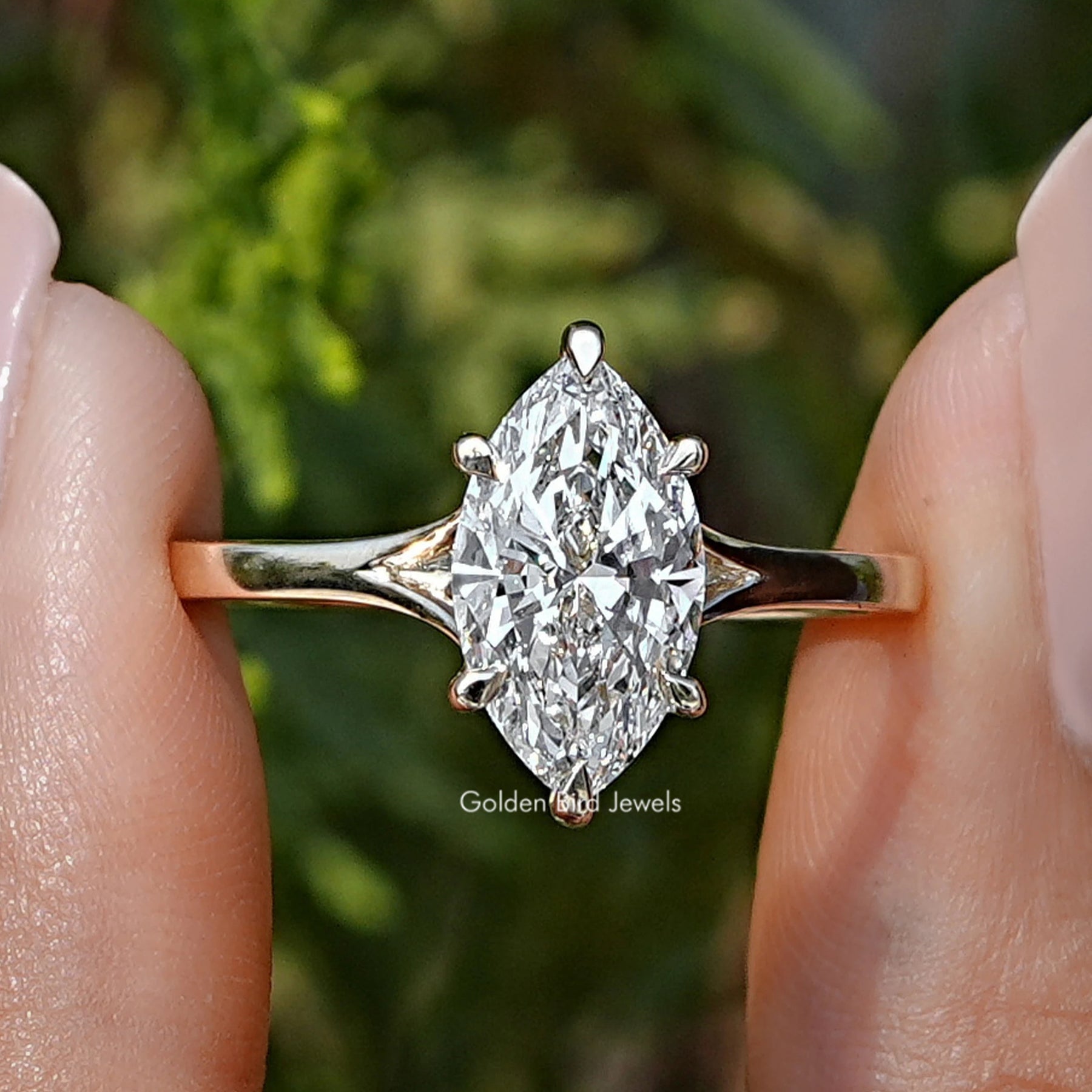 Marquise Cut Lab Grown Diamond Engagement Ring Held Between Fingers