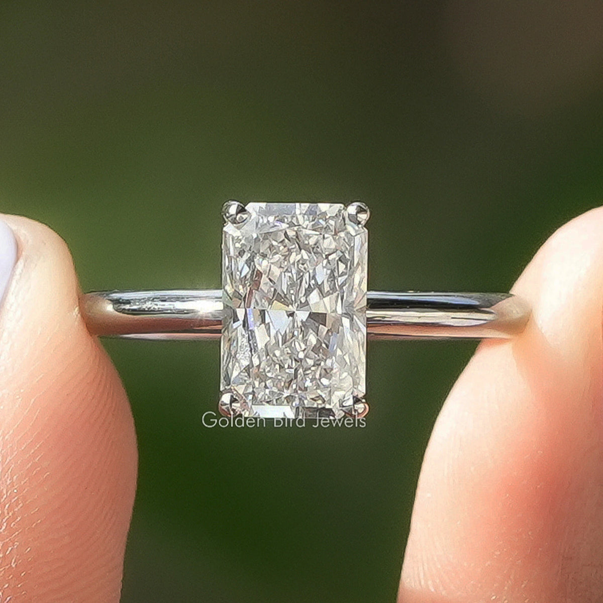 Radiant Cut Solitaire Ring Held Between Fingers