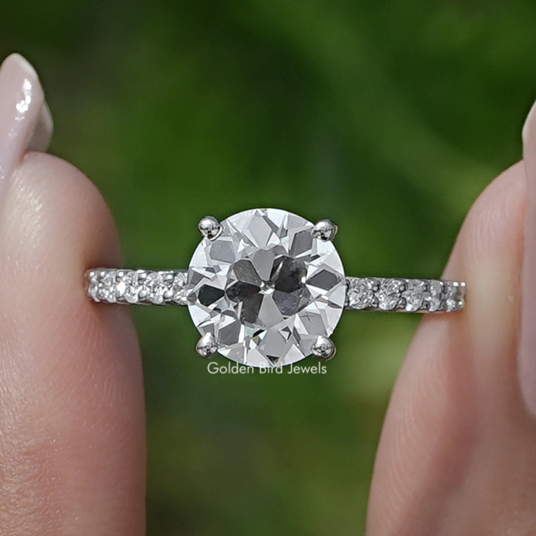 Old European Round Cut Diamond Solitaire Ring Held Between Fingers