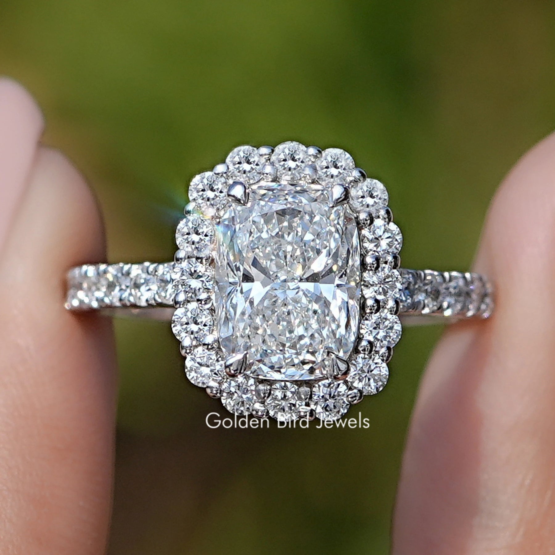 Cushion Cut Halo Accent Ring held between in fingers