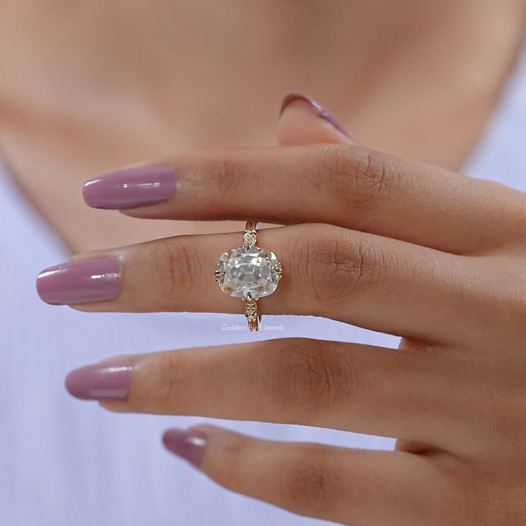 In finger front view of Elongated Cushion Cut Moissanite Ring in Yellow Gold