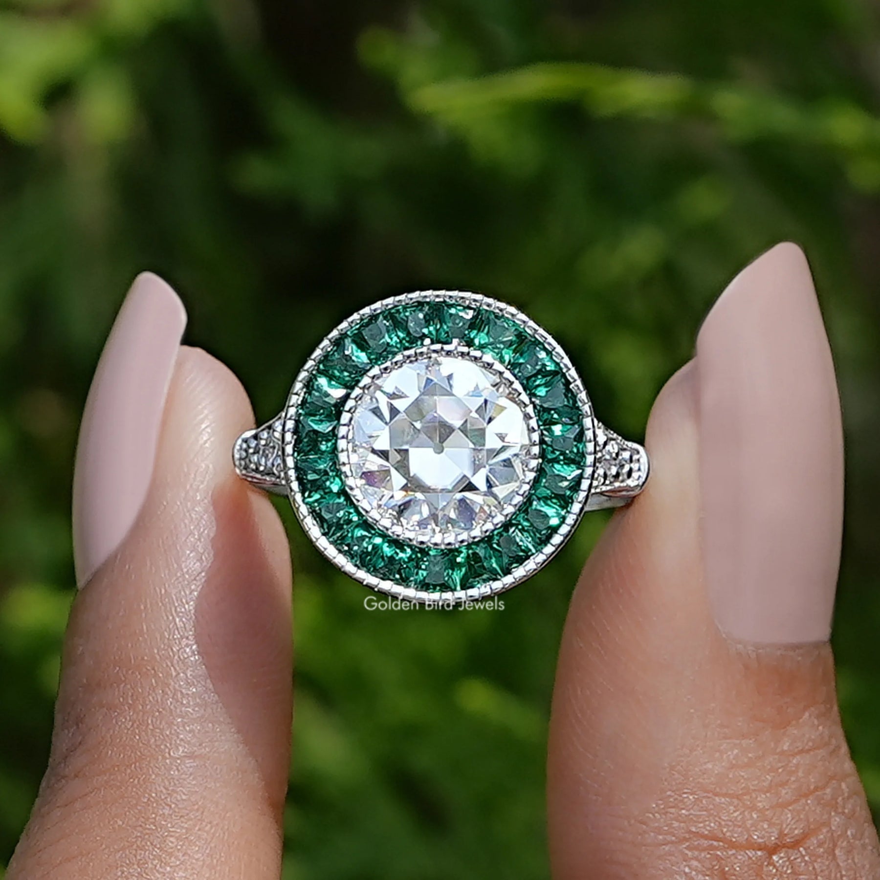 Two fingers holding the Round Cut Moissanite Halo Ring