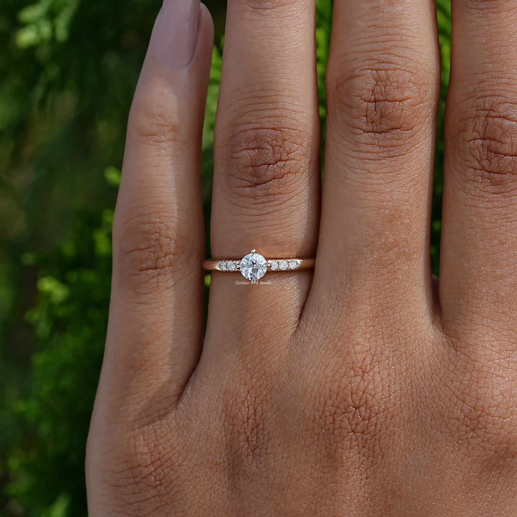 Close-Up View of Round Cut Lab Diamond Accent Ring In two fingers