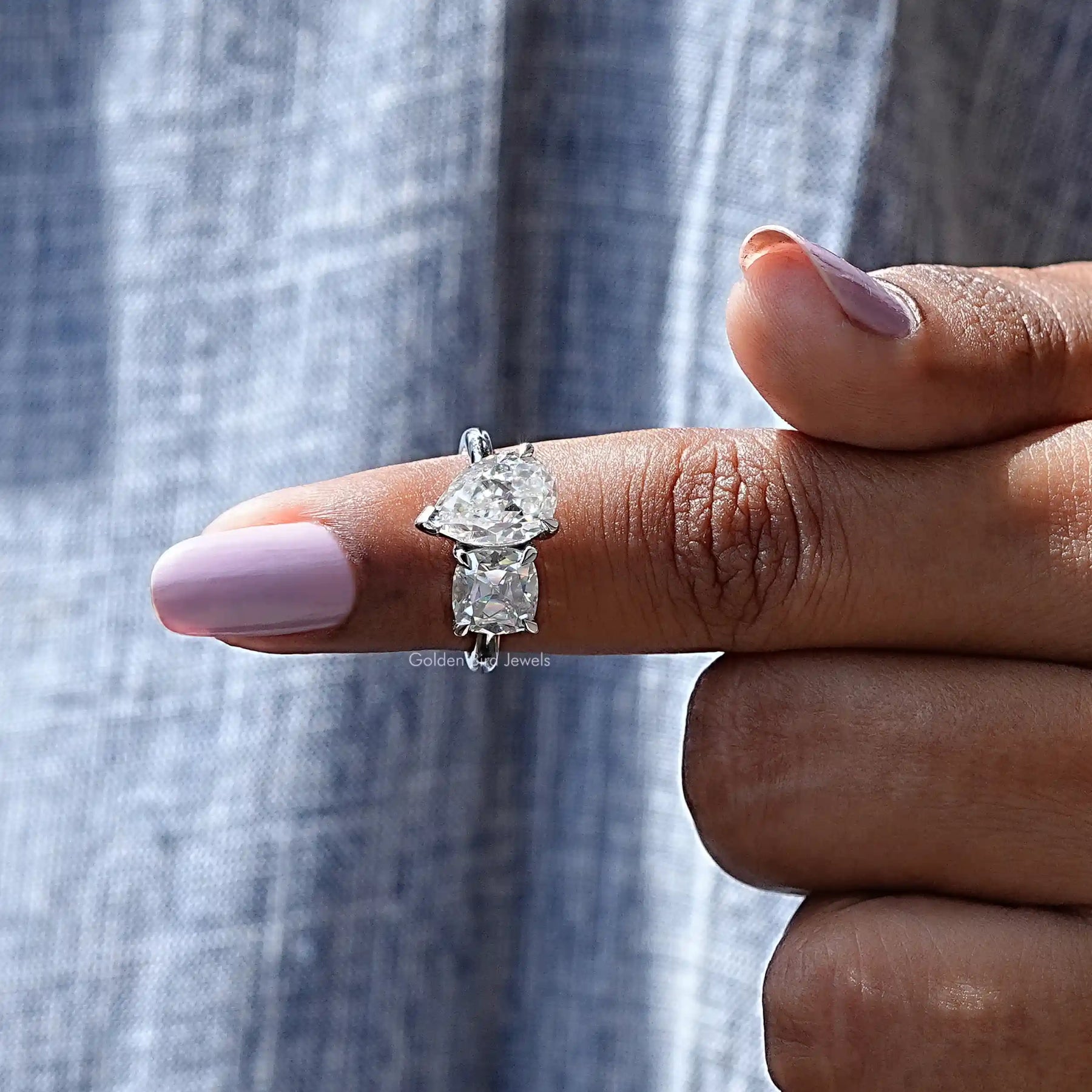In finger front View of Cushion And Old Mine Pear Cut Moissanite Ring In White Gold