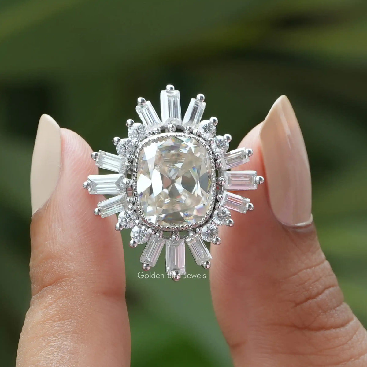 Two fingers holding the Old Mine Cushion Cut Moissanite Halo Engagement Ring