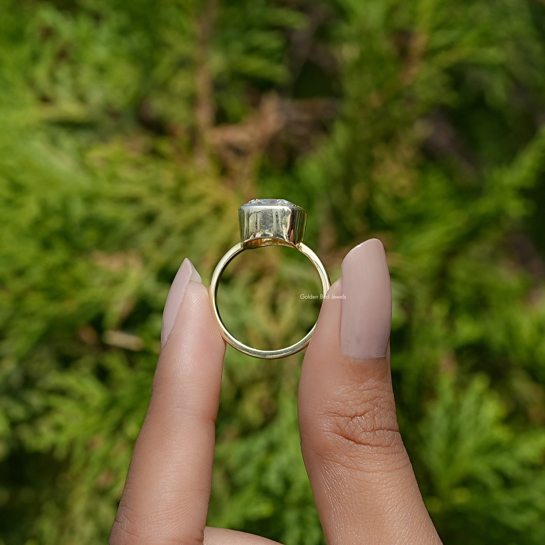 Back View of Cushion Cut Moissanite Solitaire Engagement Ring In two fingers