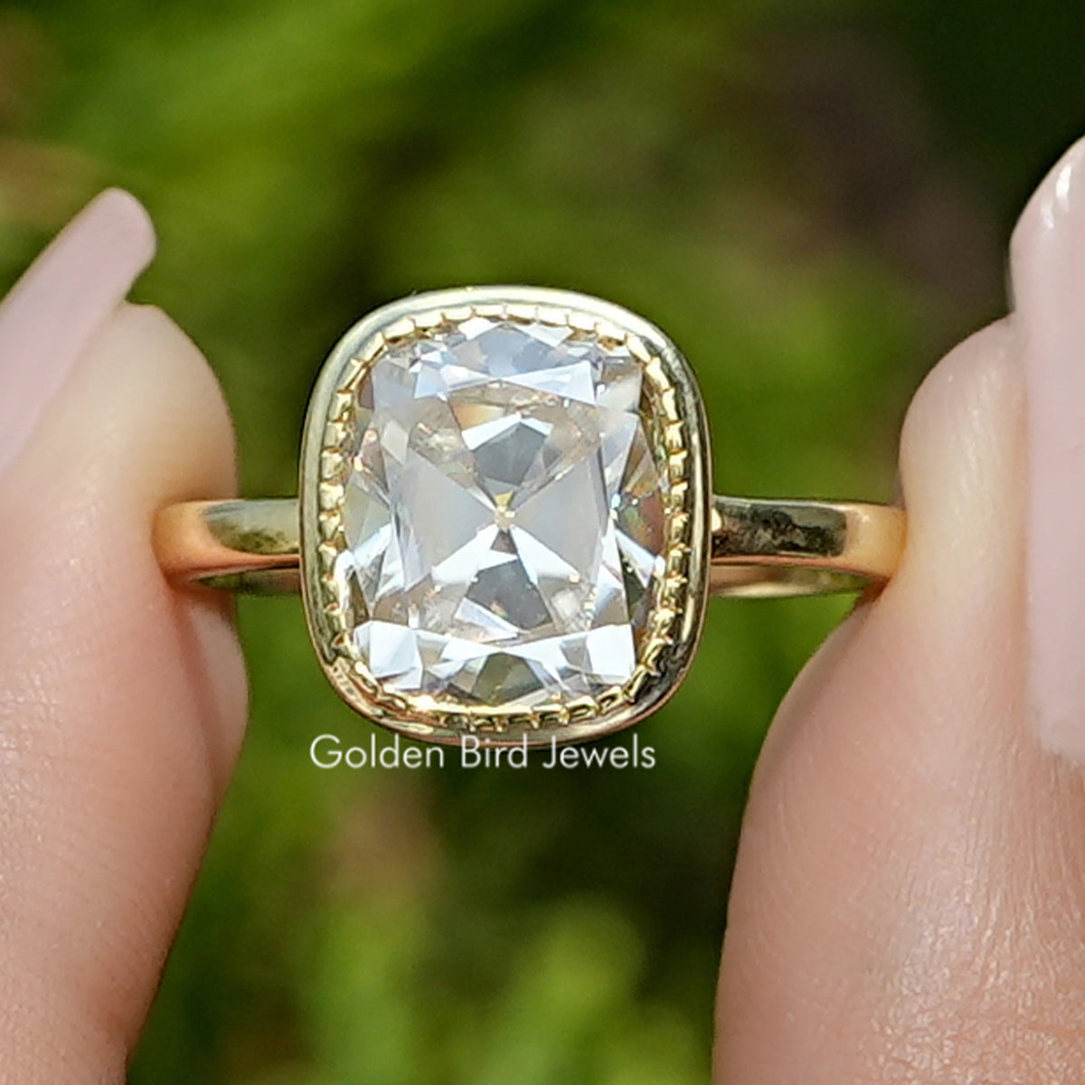 Front view of Old Mine Cushion Moissanite Solitaire Ring in two fingers