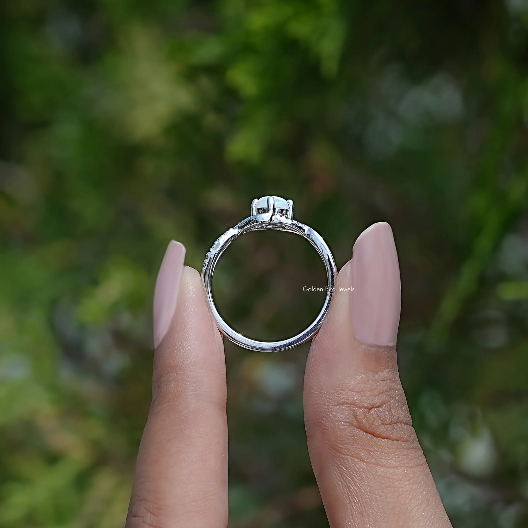 Back View of Opal Round Cut Infinity Accent Stone Ring In two fingers