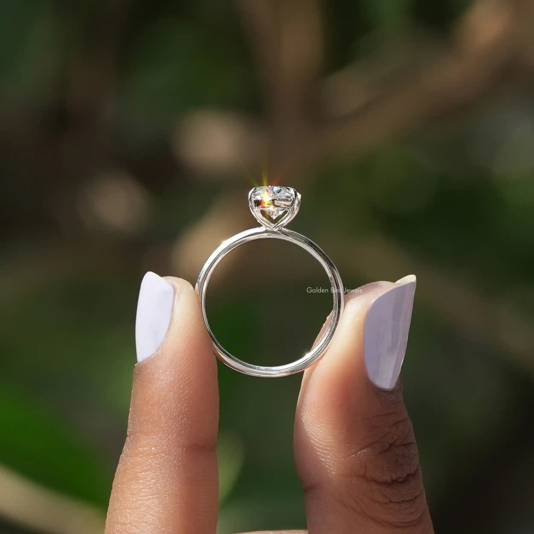 Back View of Oval Cut Diamond Solitaire Ring In two fingers