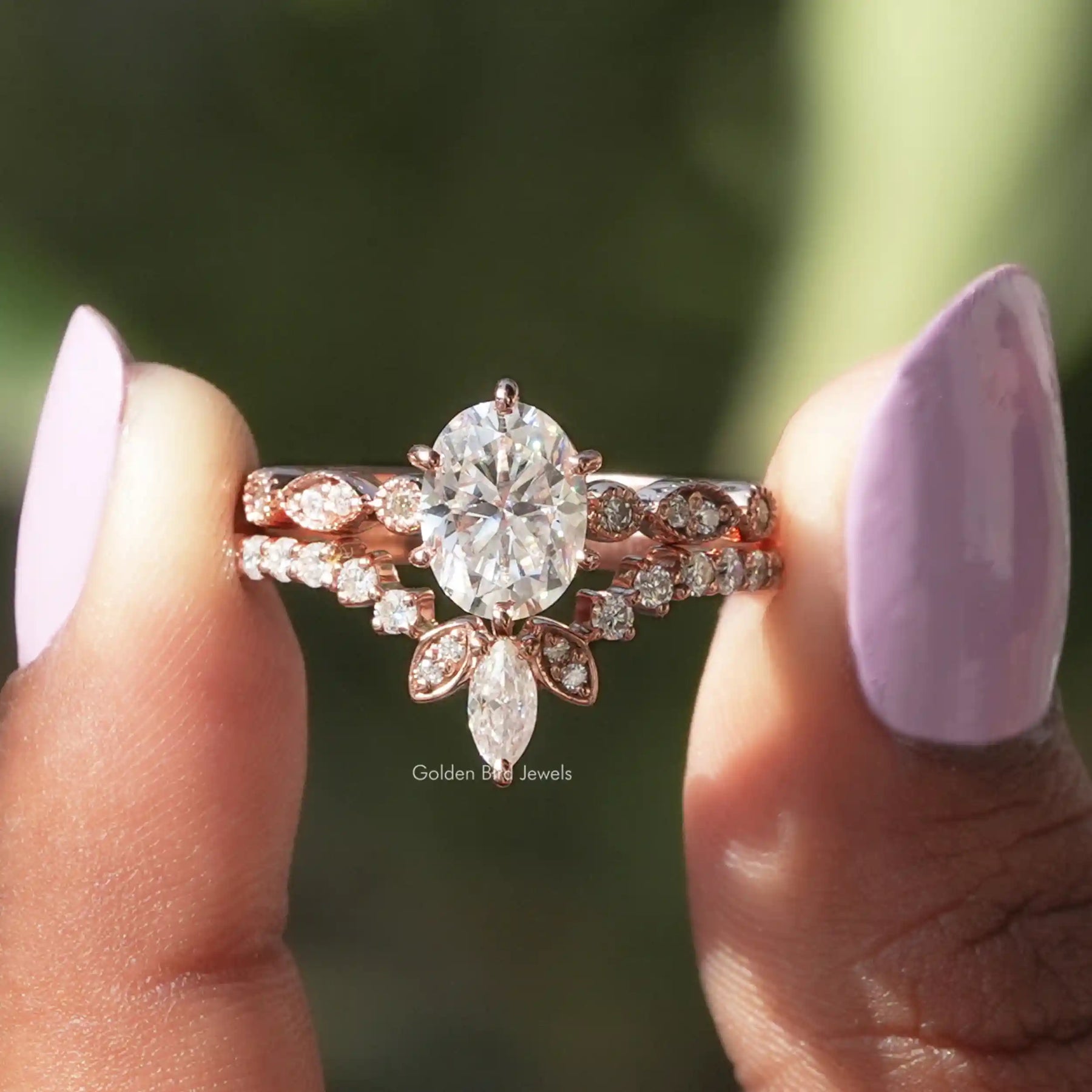 Two fingers holding the Oval Cut Moissanite Bridal Ring Set