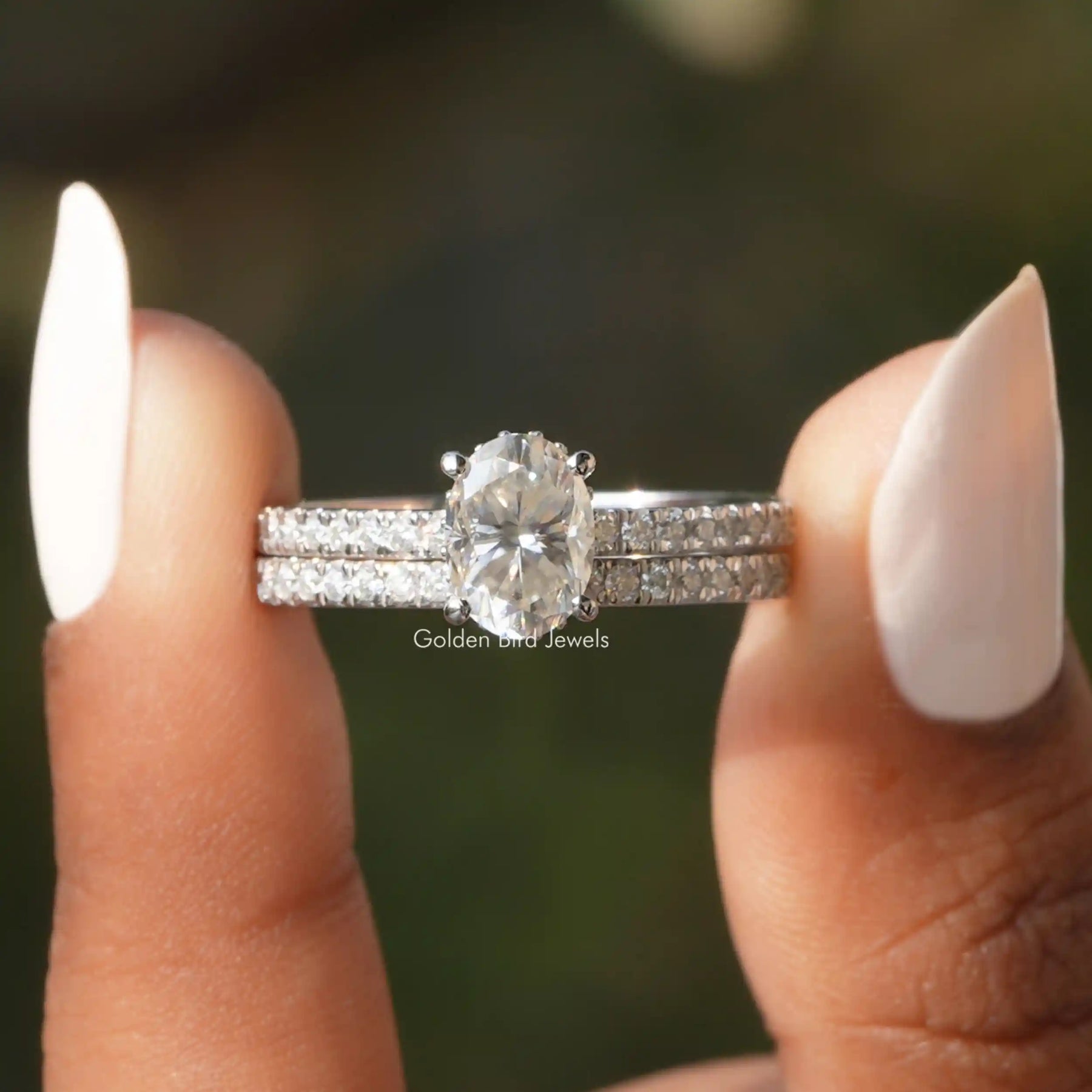 Two fingers holding the Oval Cut Moissanite Bridal Ring