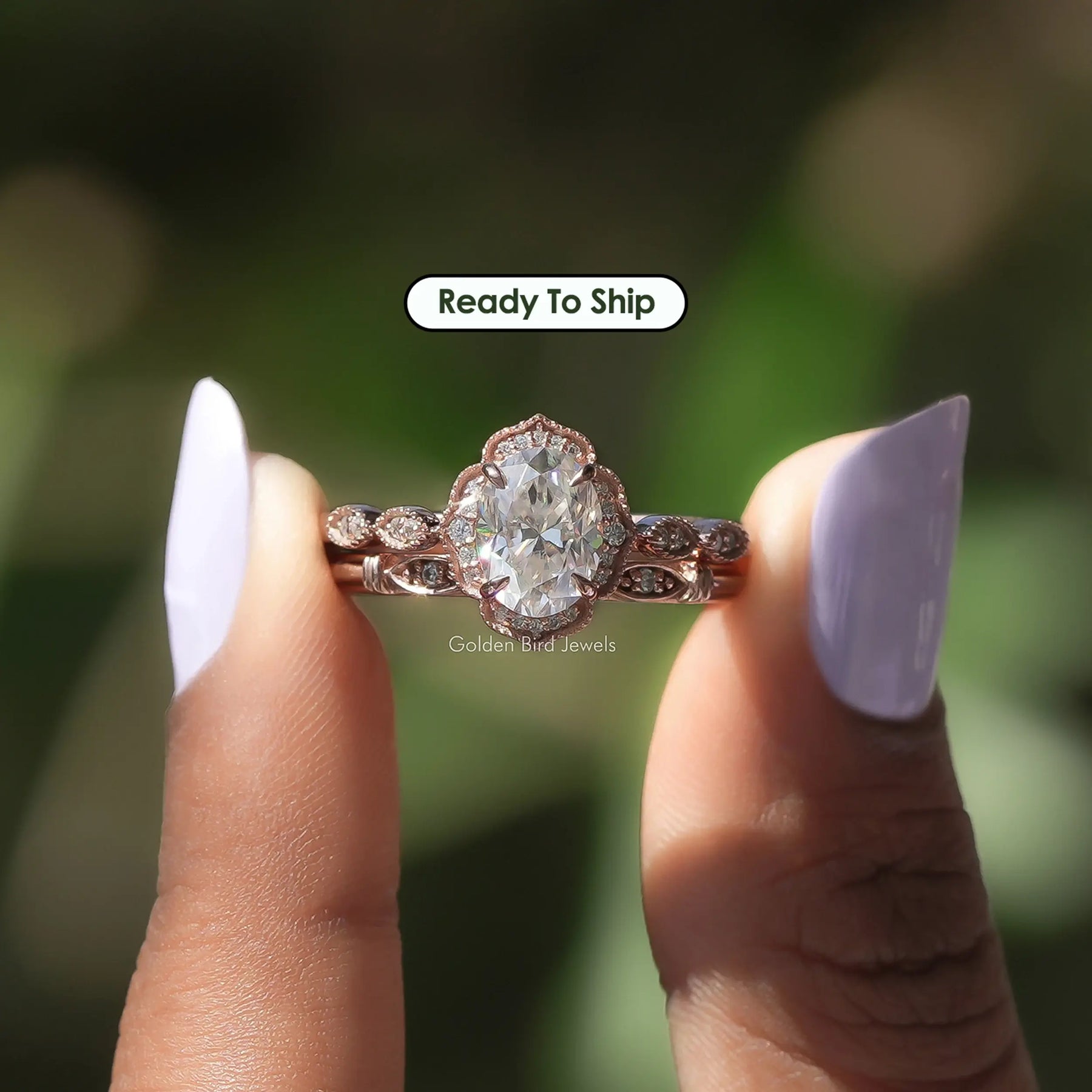 Two fingers holding the Oval Cut Moissanite Halo Wedding Ring