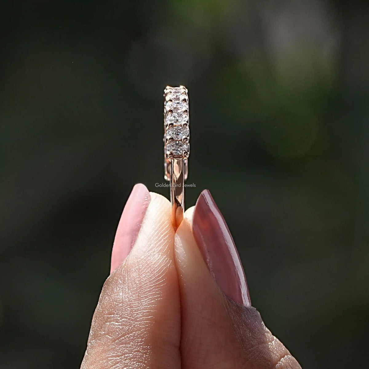 Side View of Oval Shaped Lab Diamond Half Eternity Wedding Band In two fingers