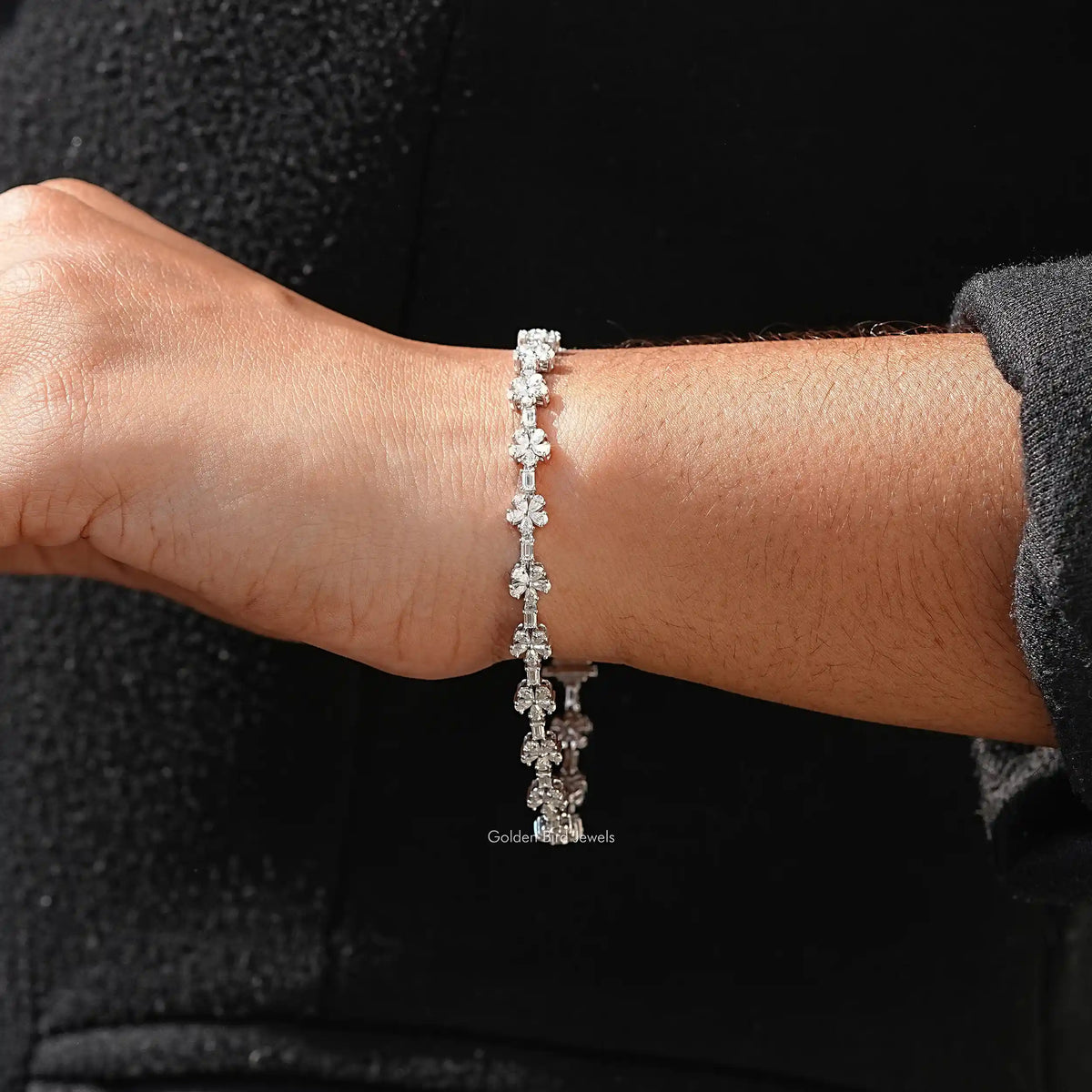 In hand view of pear and baguette moissanite halo bracelet
