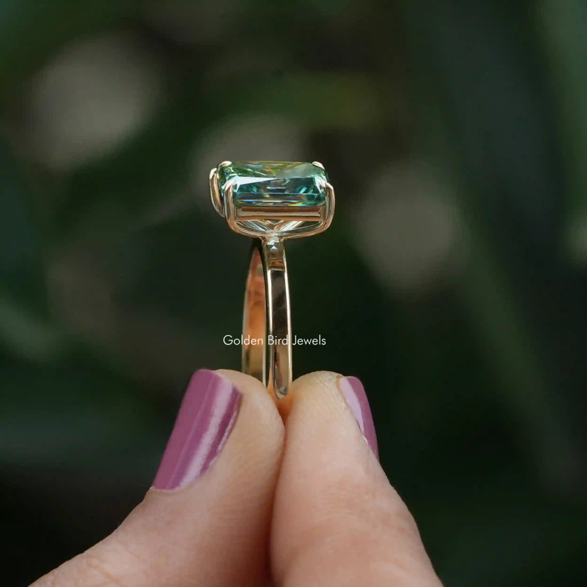 Side View of Pear And Radiant Cut Moissanite Ring In two fingers