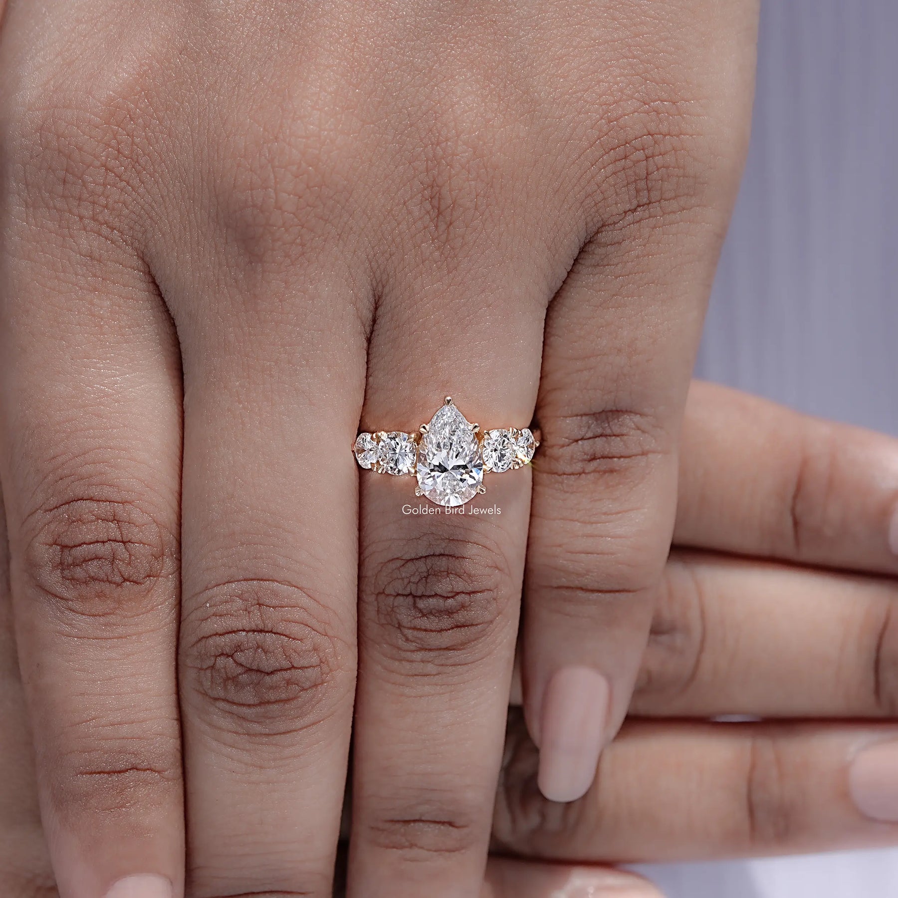 Top view of Pear Cut Diamond Five Stone Ring held in finger