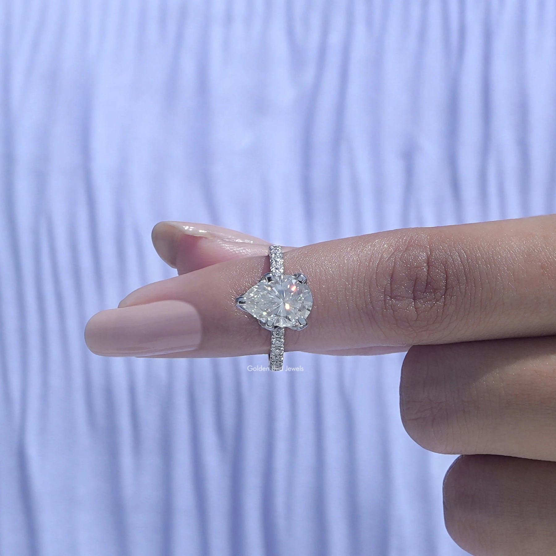 In finger front View of Moissanite Pear Shaped Accent Stone Ring
