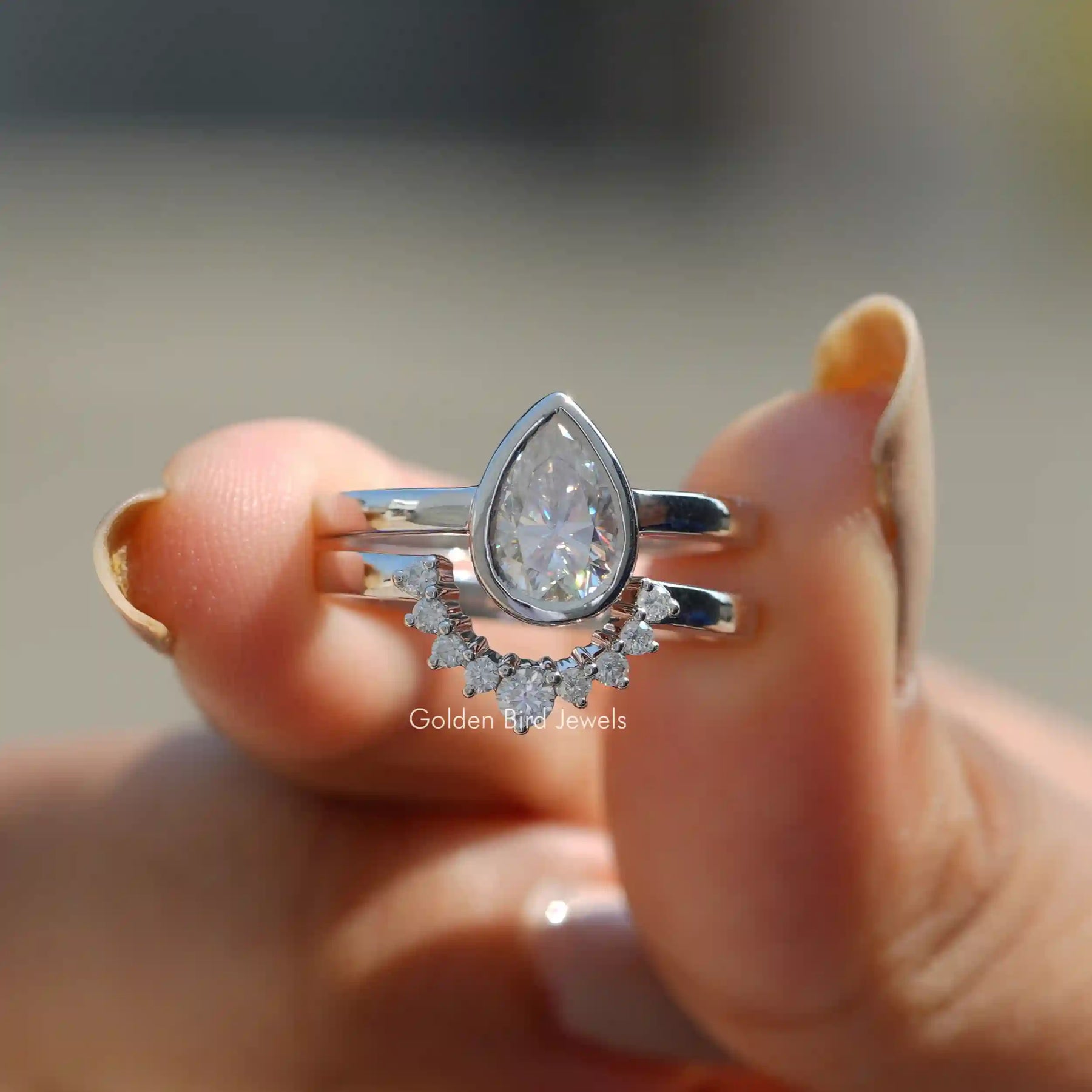 Front View of Pear Cut Moissanite Vintage Style Ring In Two Fingers