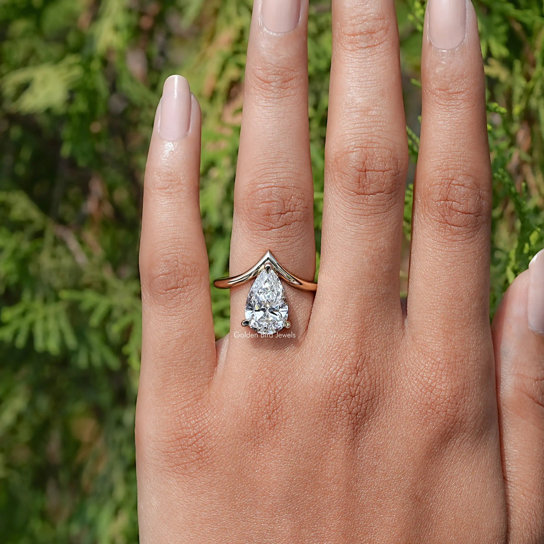 View of Pear Cut Yellow Gold Curved V Shaped Solitaire Ring In Finger