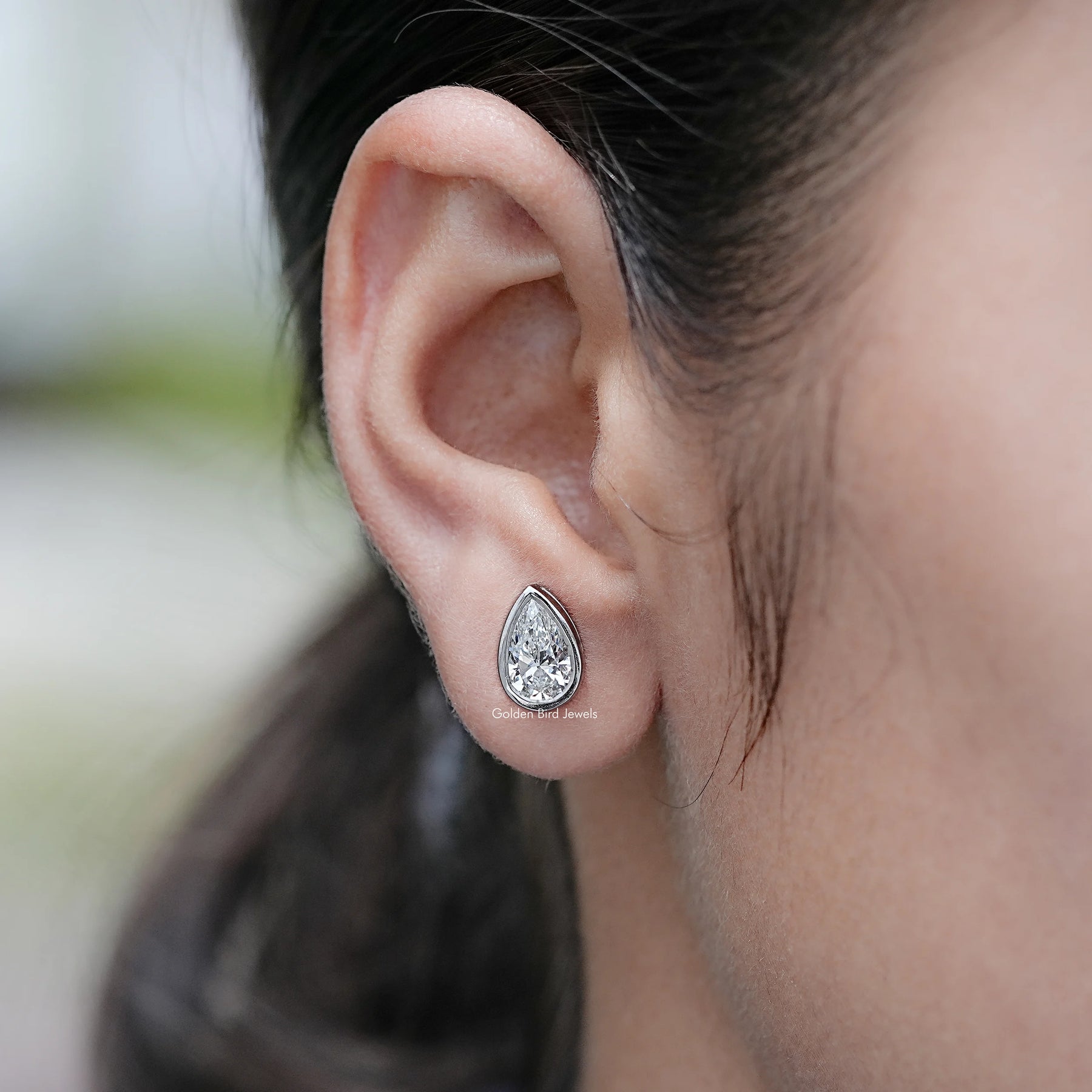 In Ear View of Bezel Set Pear Lab Diamond Stud Earrings On Ear