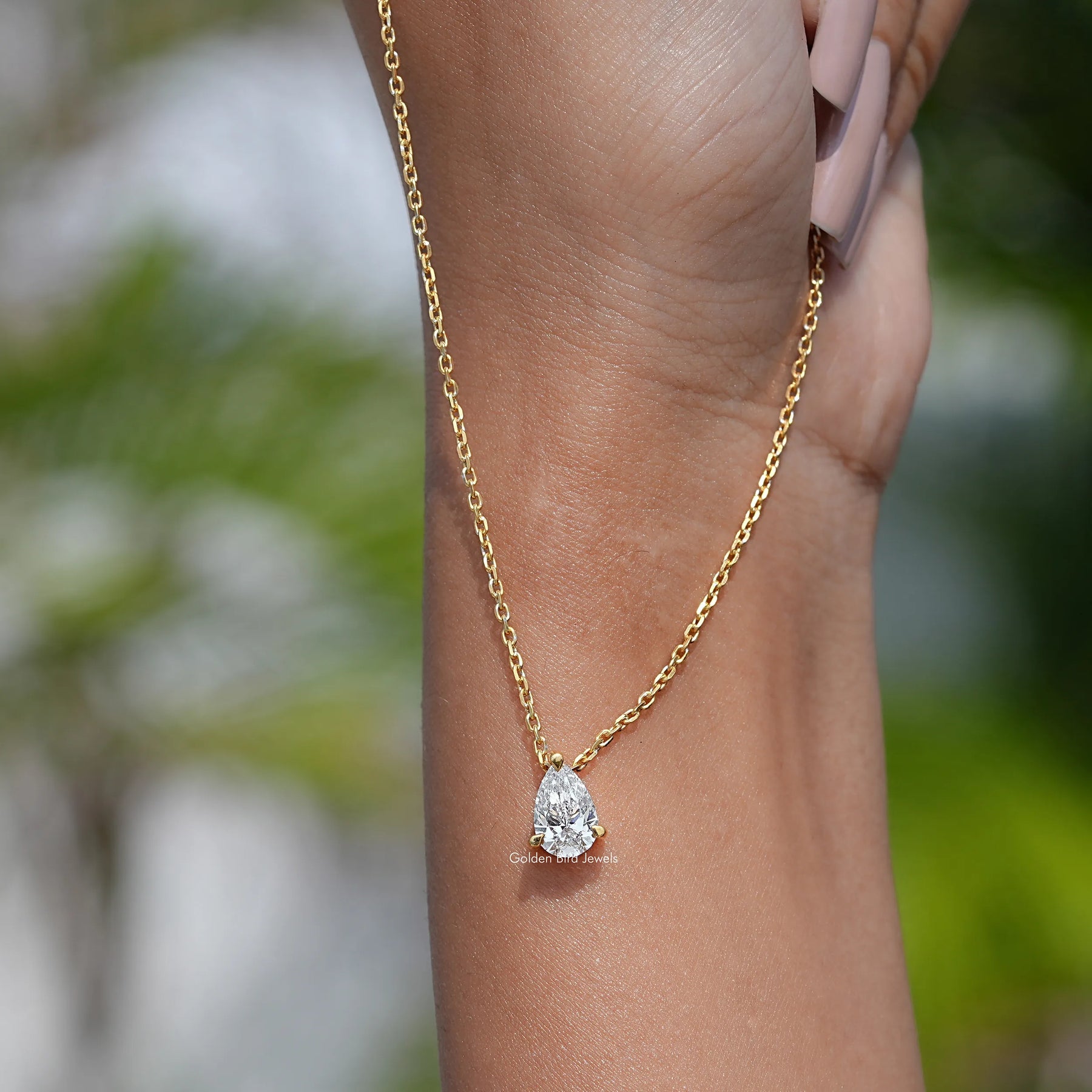 In hand showing view of diamond solitaire pendant