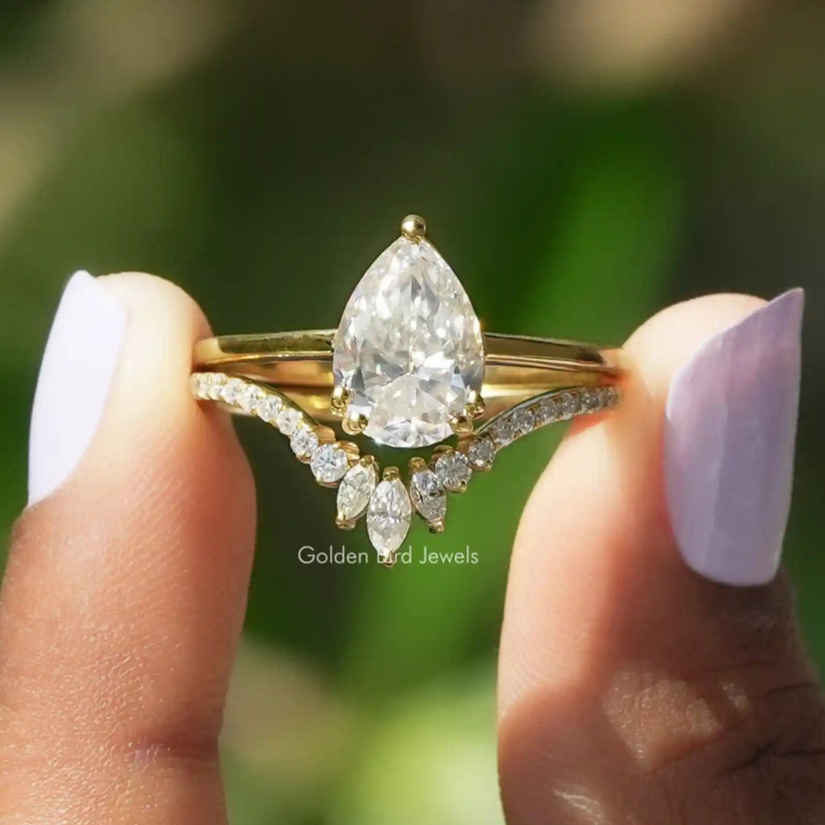 Two fingers holding the Pear Cut Moissanite Bridal Ring