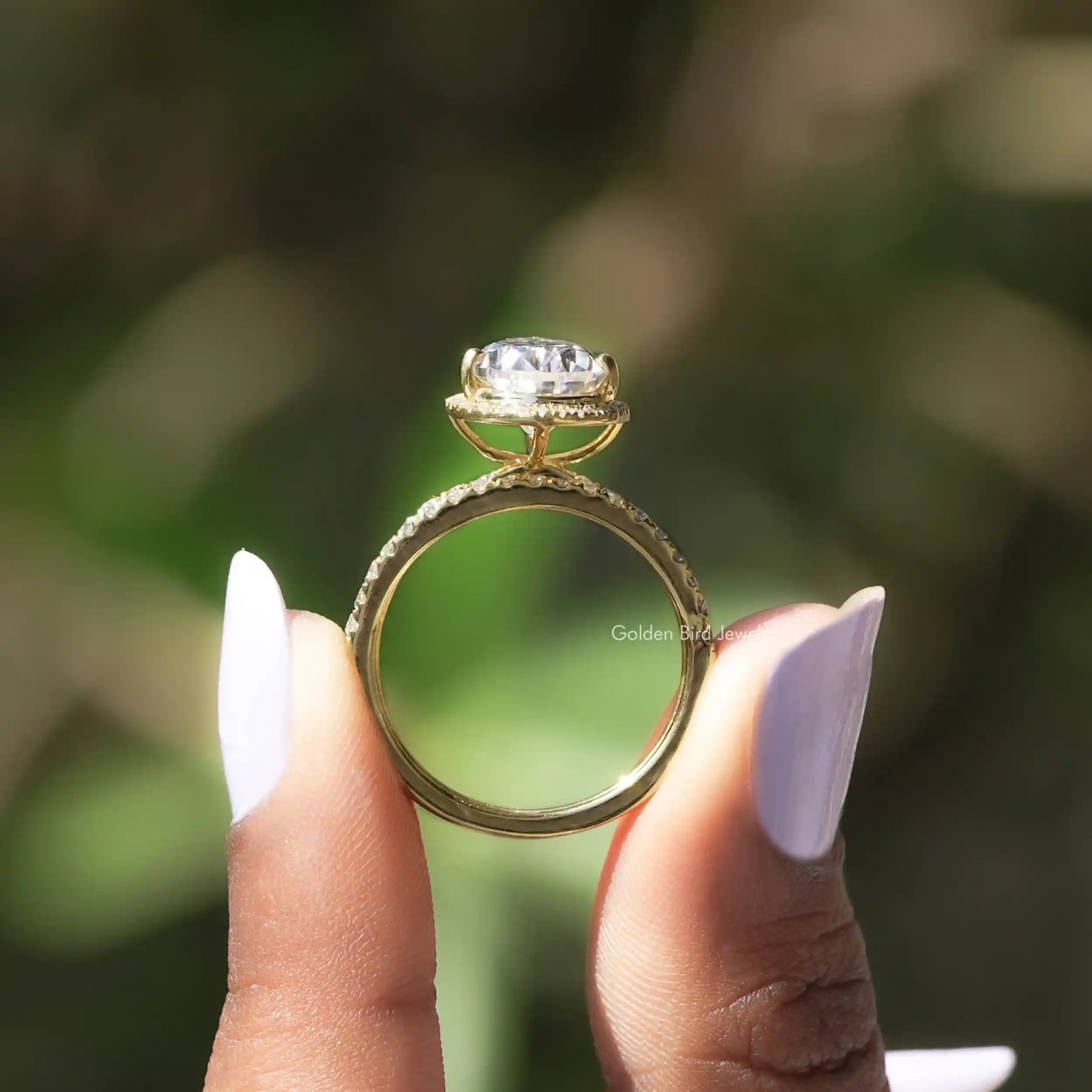 Back View of Pear Cut Moissanite Halo Engagement Ring In two fingers