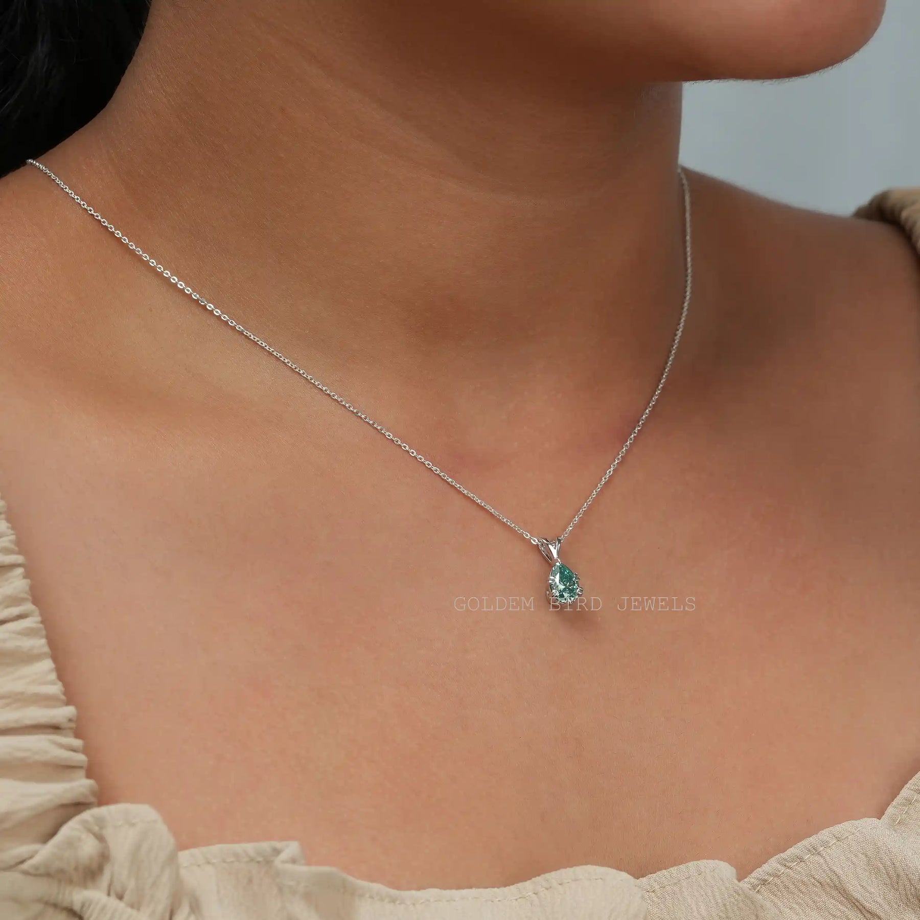 In neck side view of blue pear cut moissanite pendant