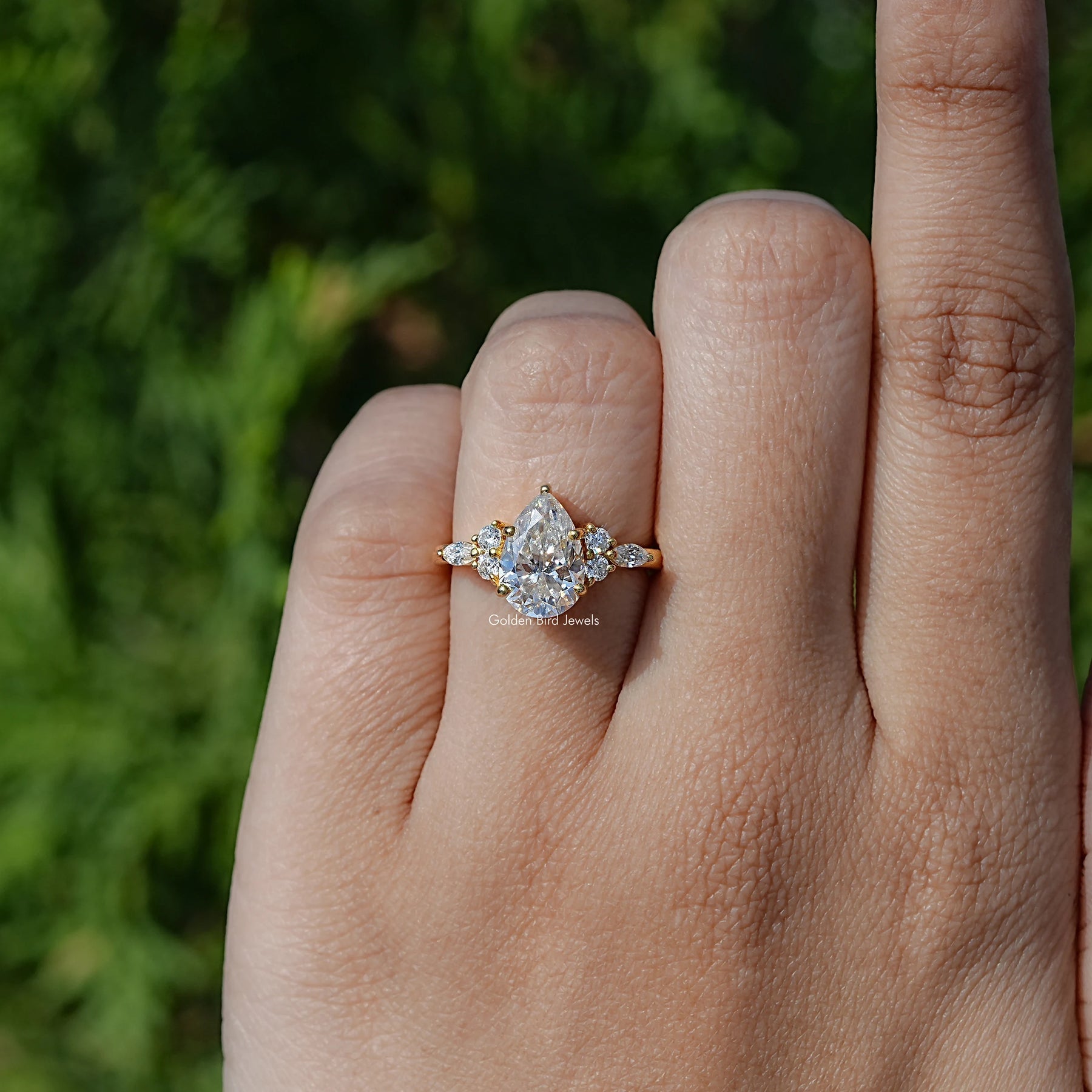 In finger front view of Pear cut moissanite Accent engagement ring