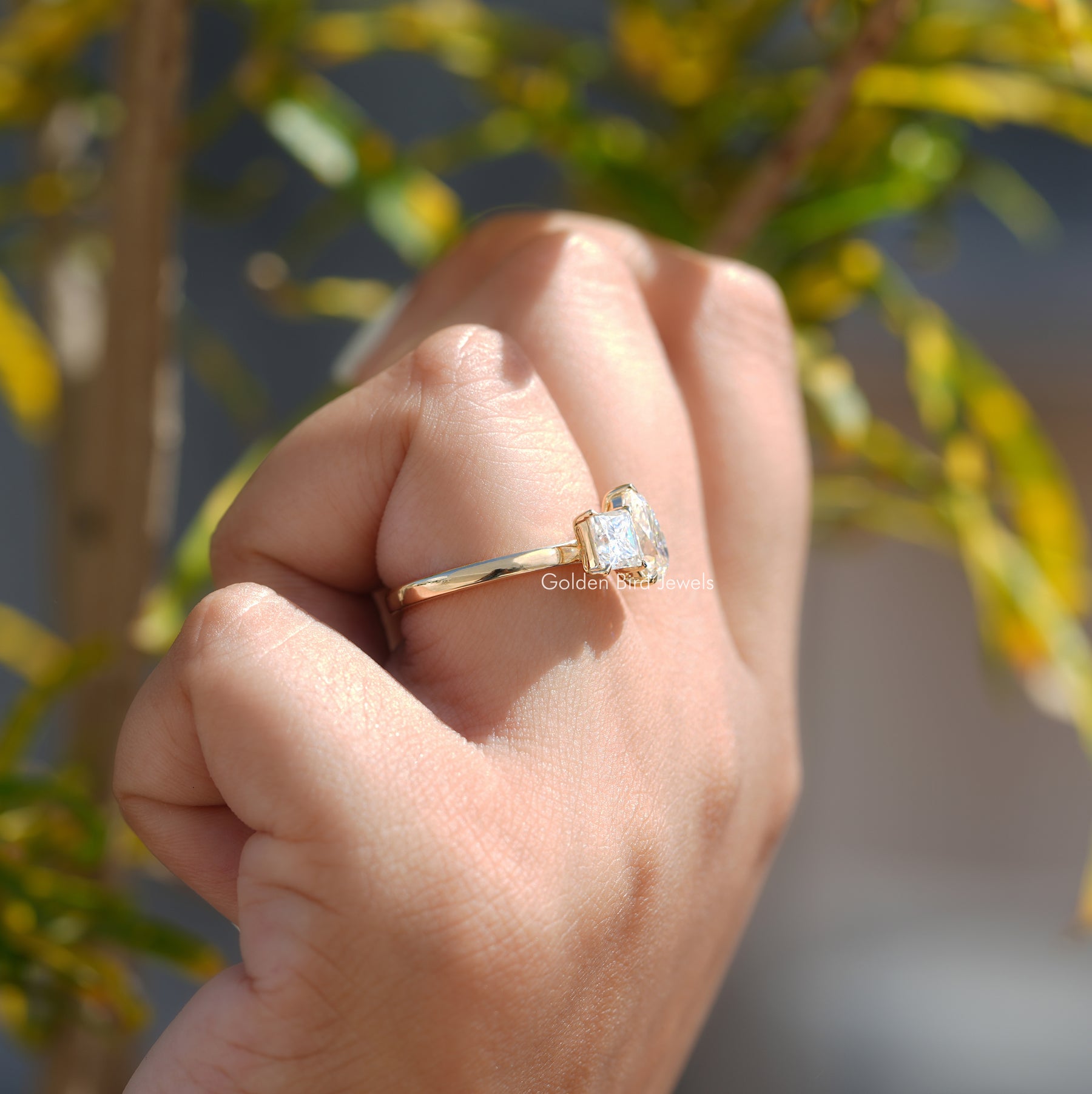 Close-Up View of Pear And Princess Cut Moissanite Ring In Yellow Gold