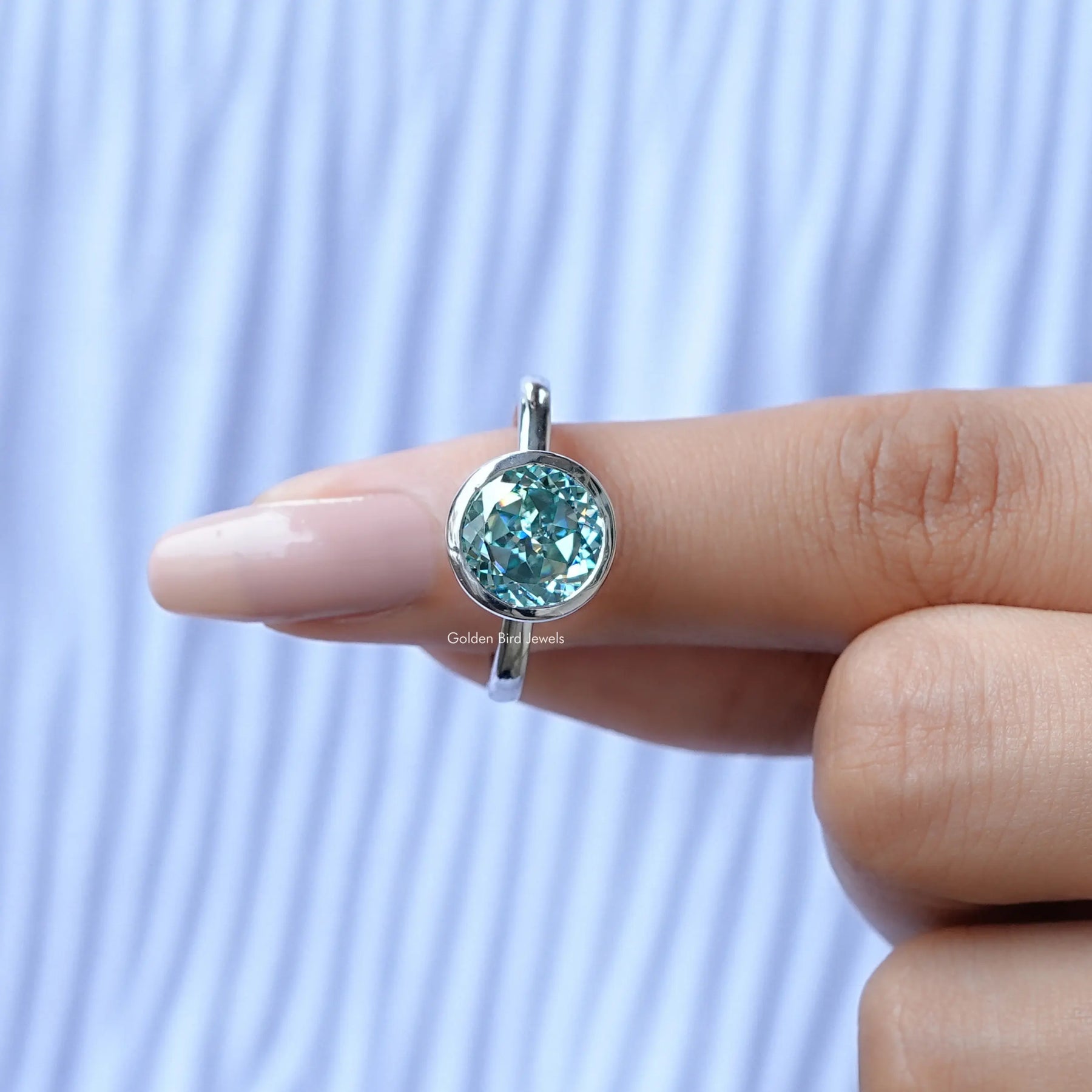 In finger front View of Round Cut Moissanite Bezel Set Ring In White Gold