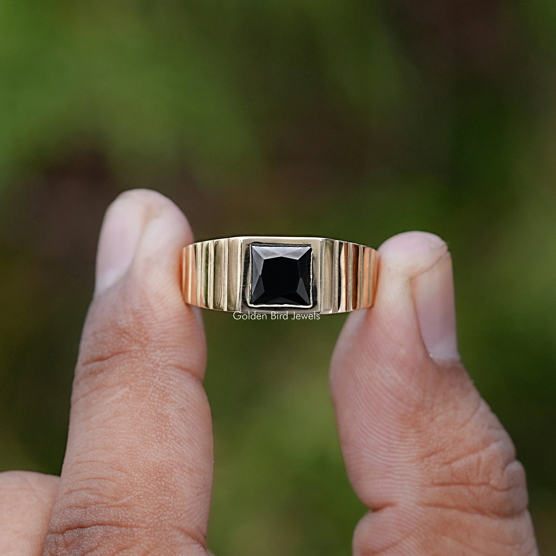 Front view of Princess Cut Black Gemstone ring holding in two fingers