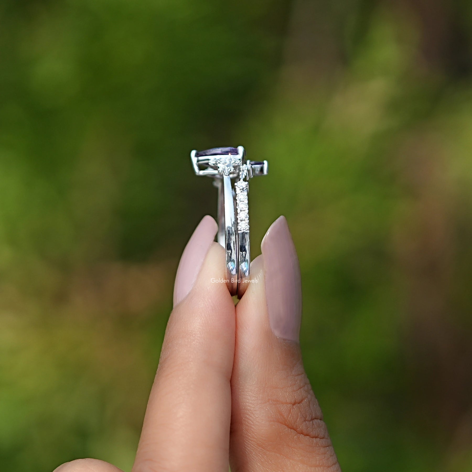 Side View of Pear Amethyst Gemstone Ring In two fingers