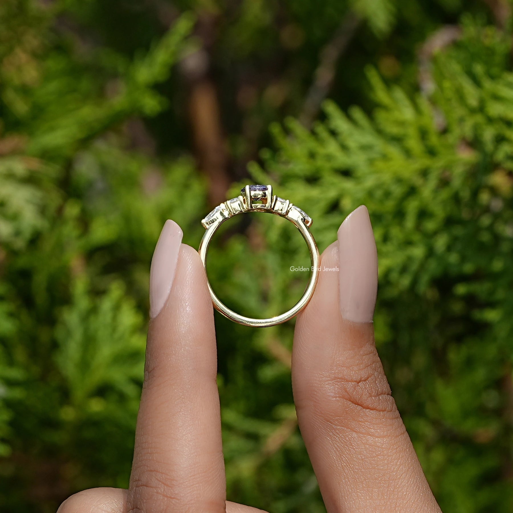 Back View of Amethyst Round Cut Gemstone Accent Ring In two fingers