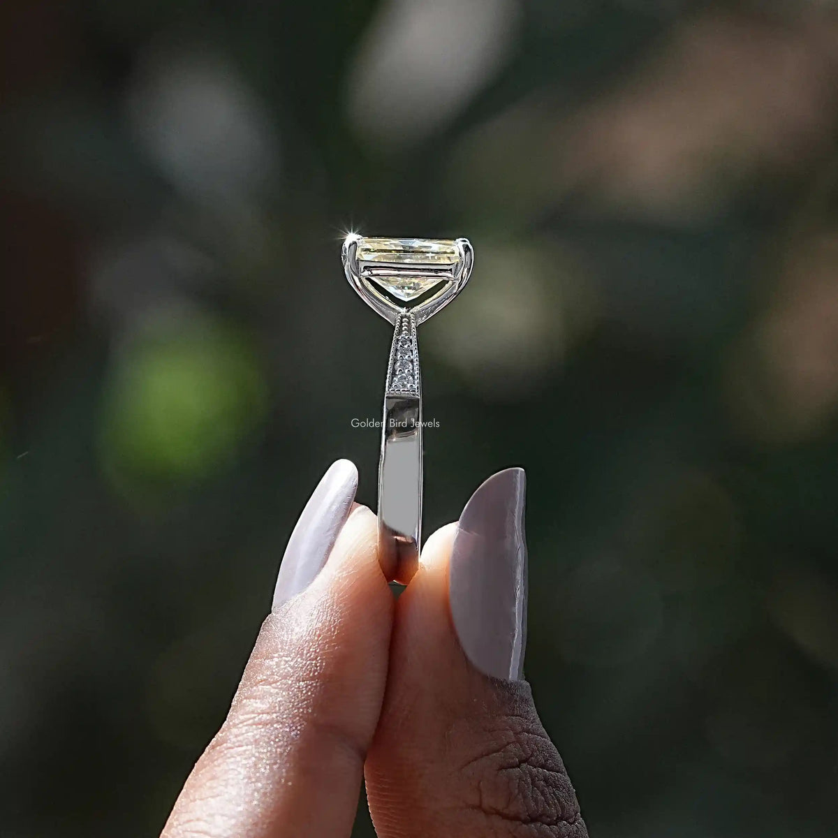 Side View of Radiant Cut Moissanite Accent Stone Ring In two fingers