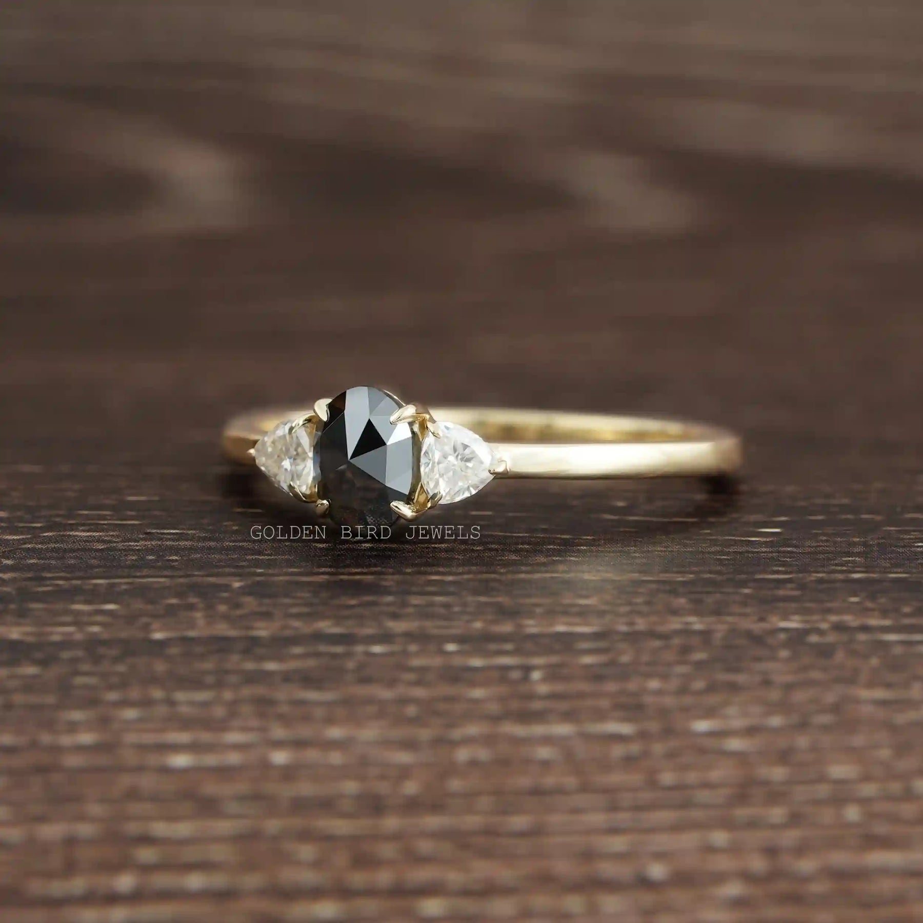 View of Black Oval Cut Moissanite Three Stone Ring In Yellow Gold