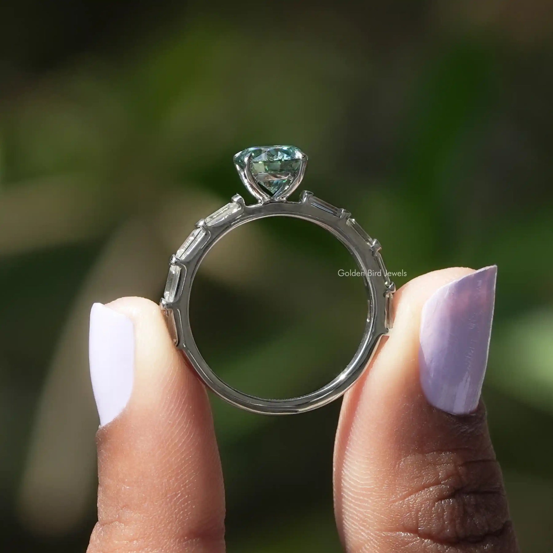 Back View of Moissanite Round And Baguette Cut Ring In two fingers