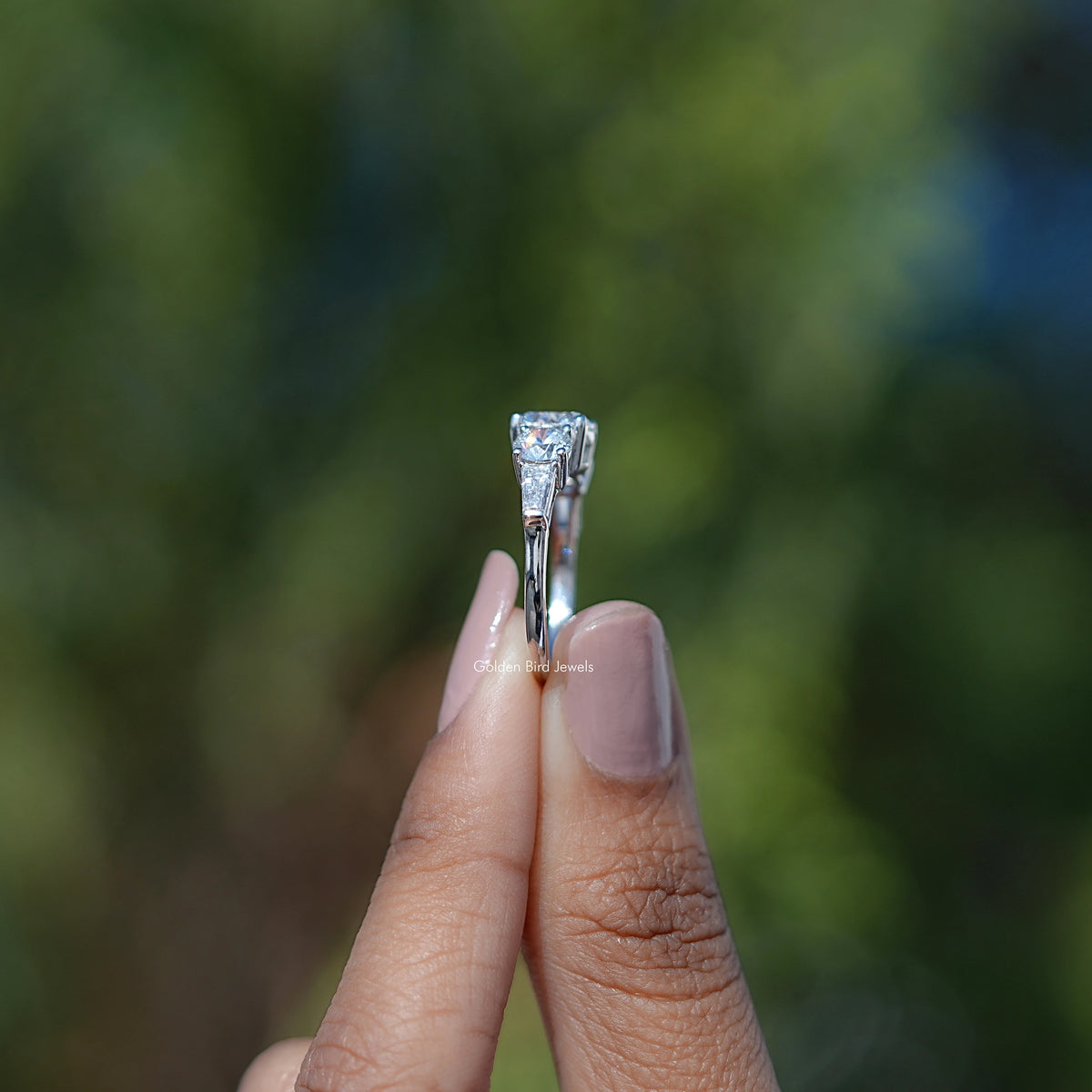 Side View of Tapered Baguette Cut Five Stone Diamond Engagement Ring In two fingers