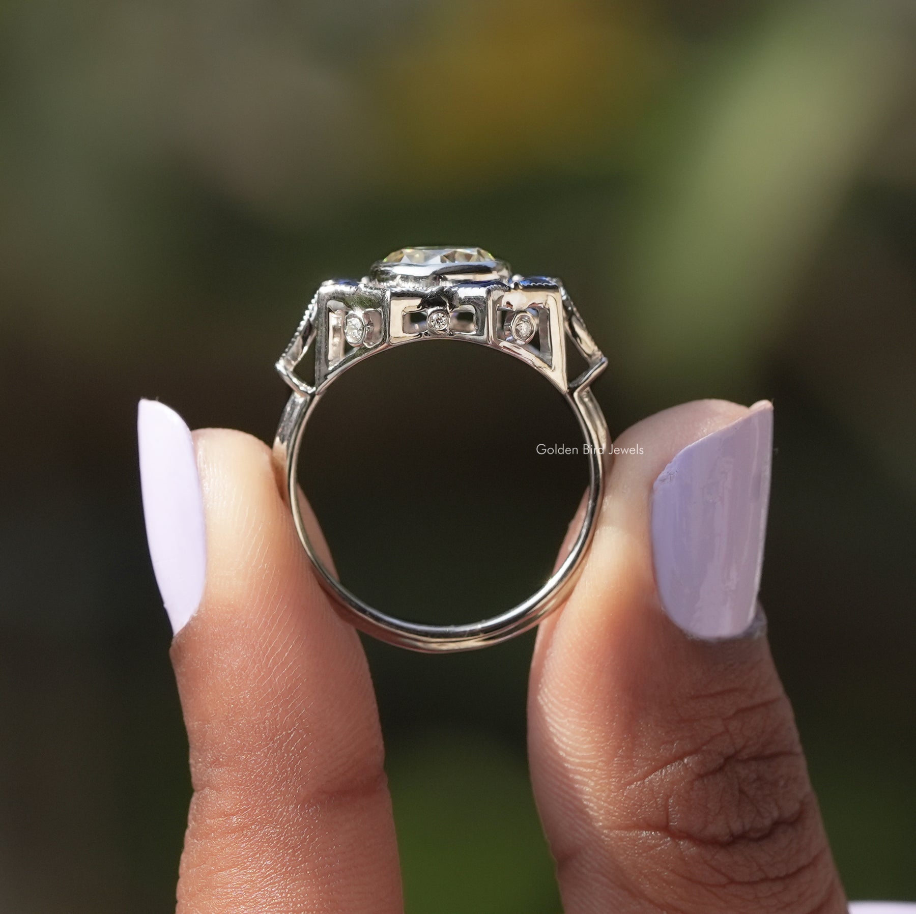 Back View of Round Cut Bezel Set Moissanite Ring In two fingers