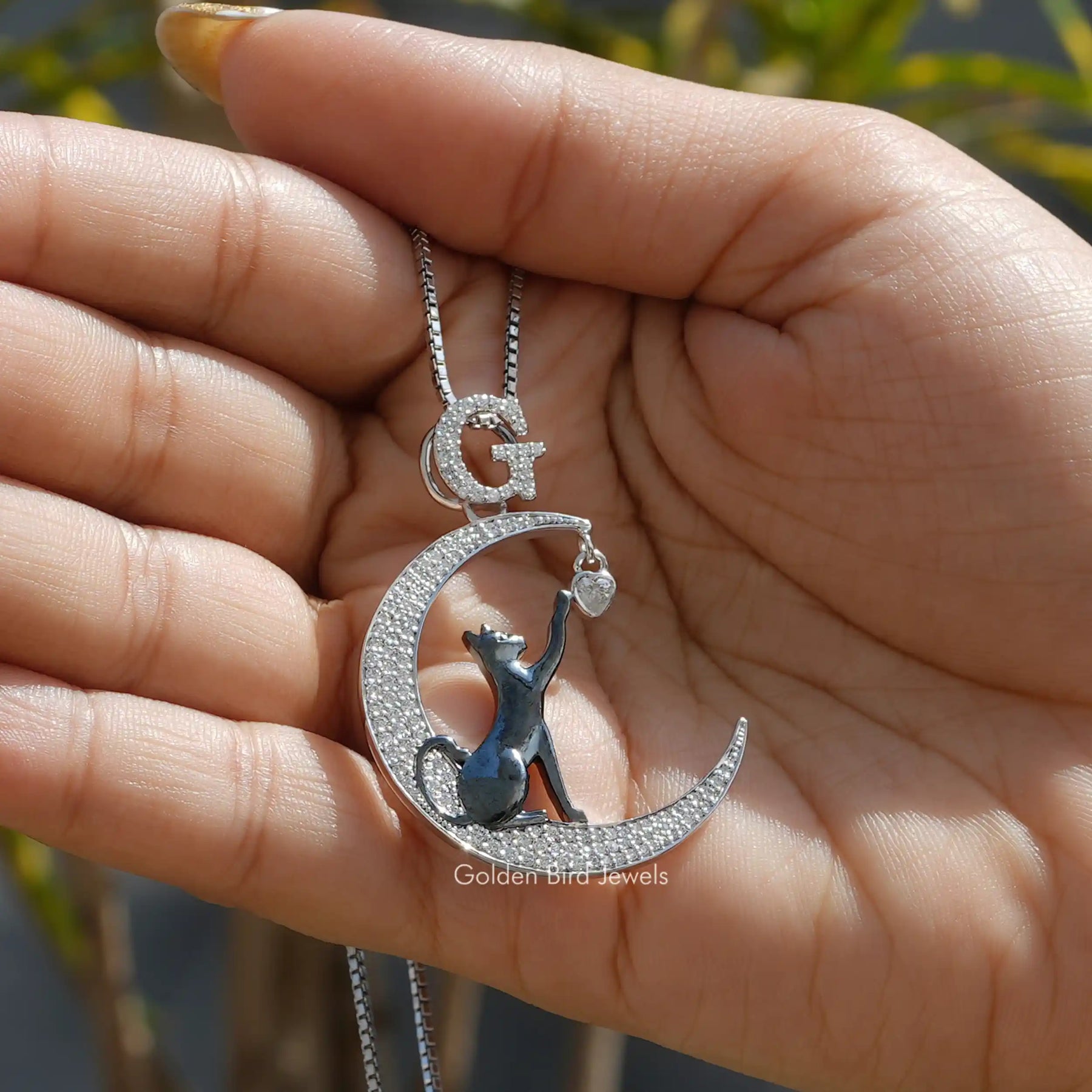 In hand showing view of moissanite pendant
