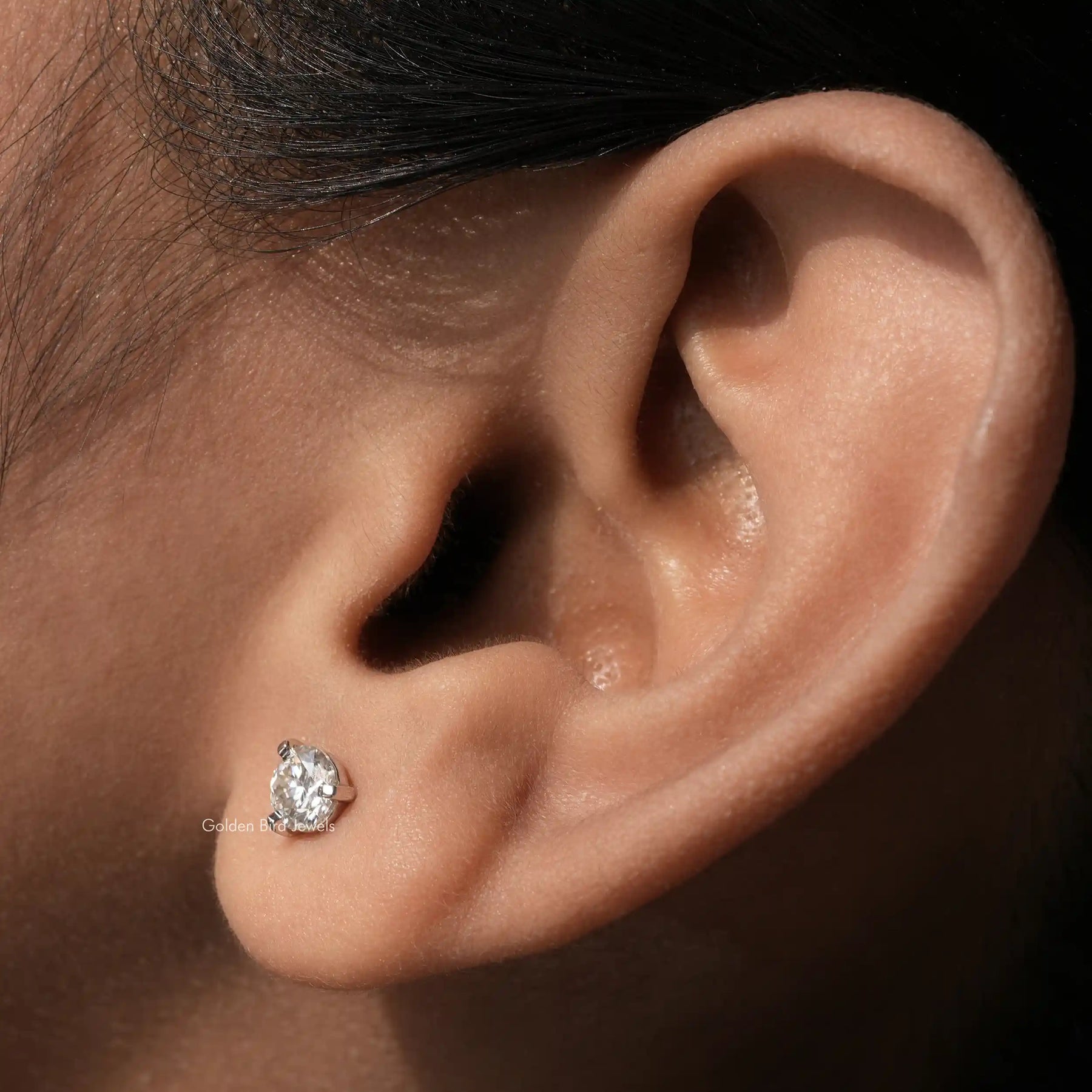 In ear front view of round cut moissanite solitaire stud earrings