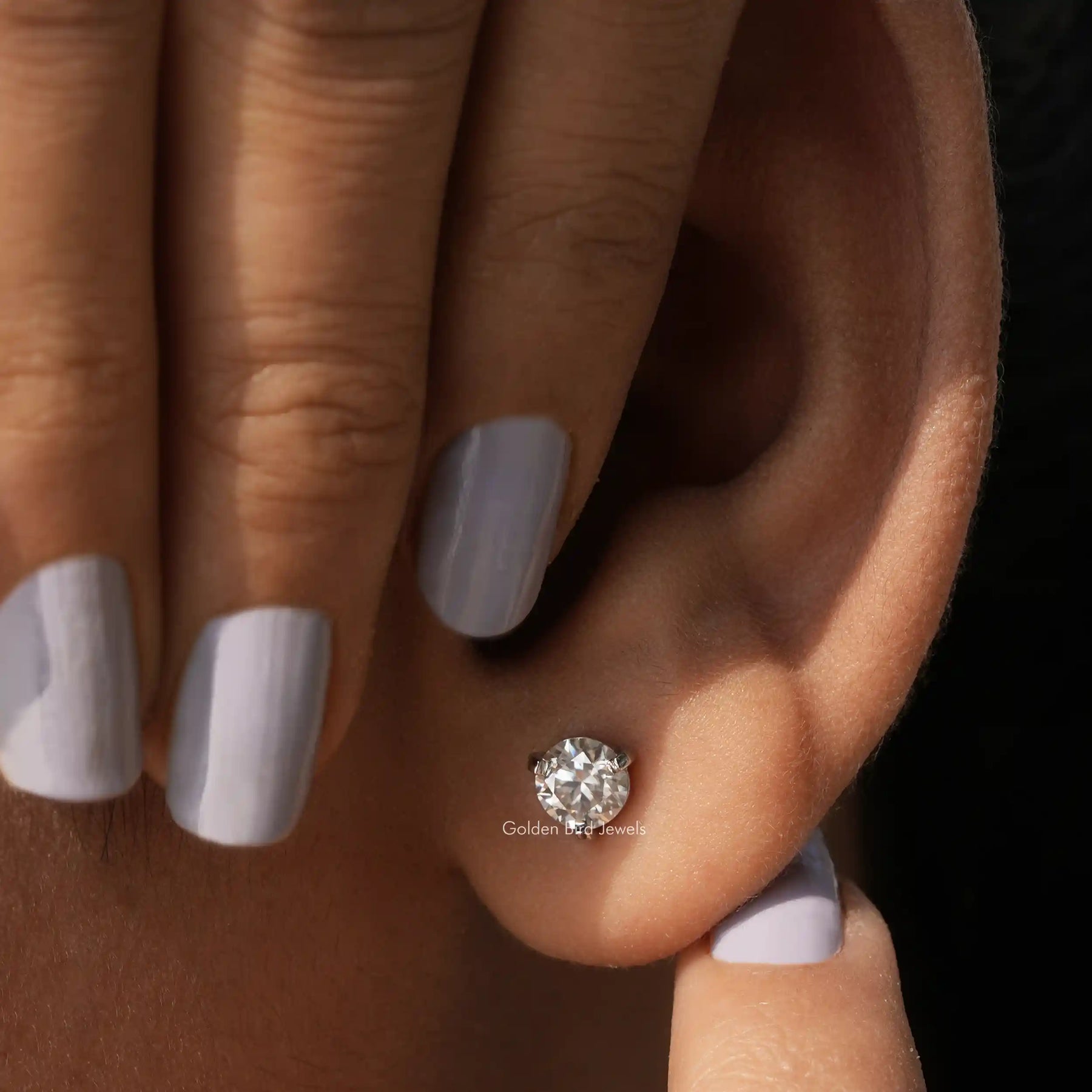 Close view of stud earrings made of round cut stones