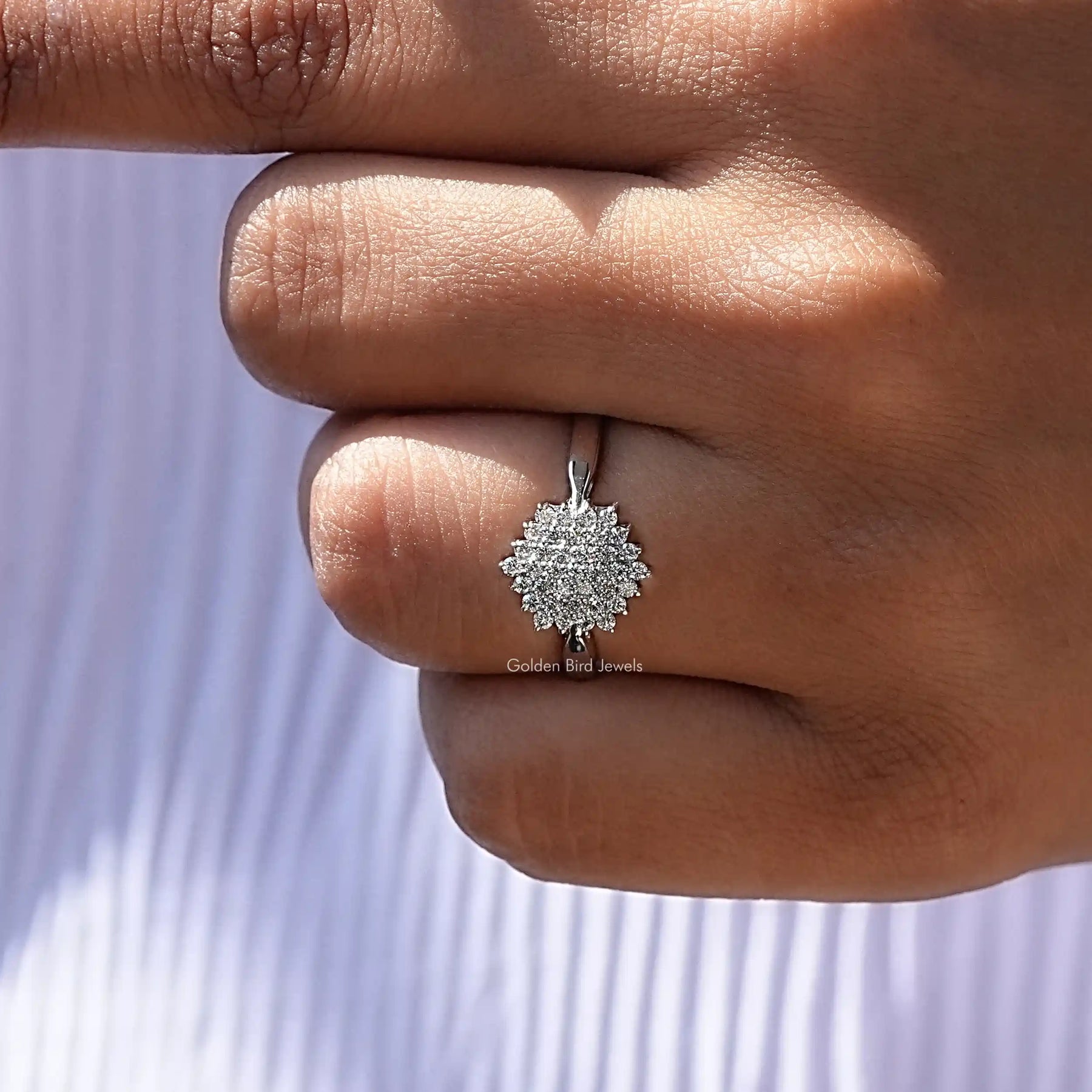On finger front view of cluster ring with round cut diamonds