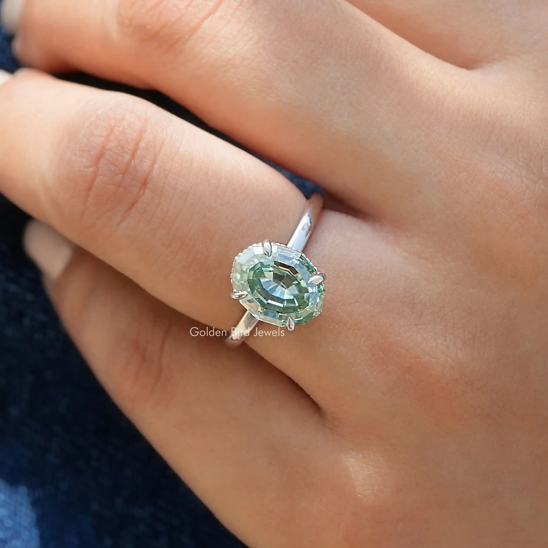 Close-Up View of Blue Step Cut Oval Hidden Halo Ring In White Gold