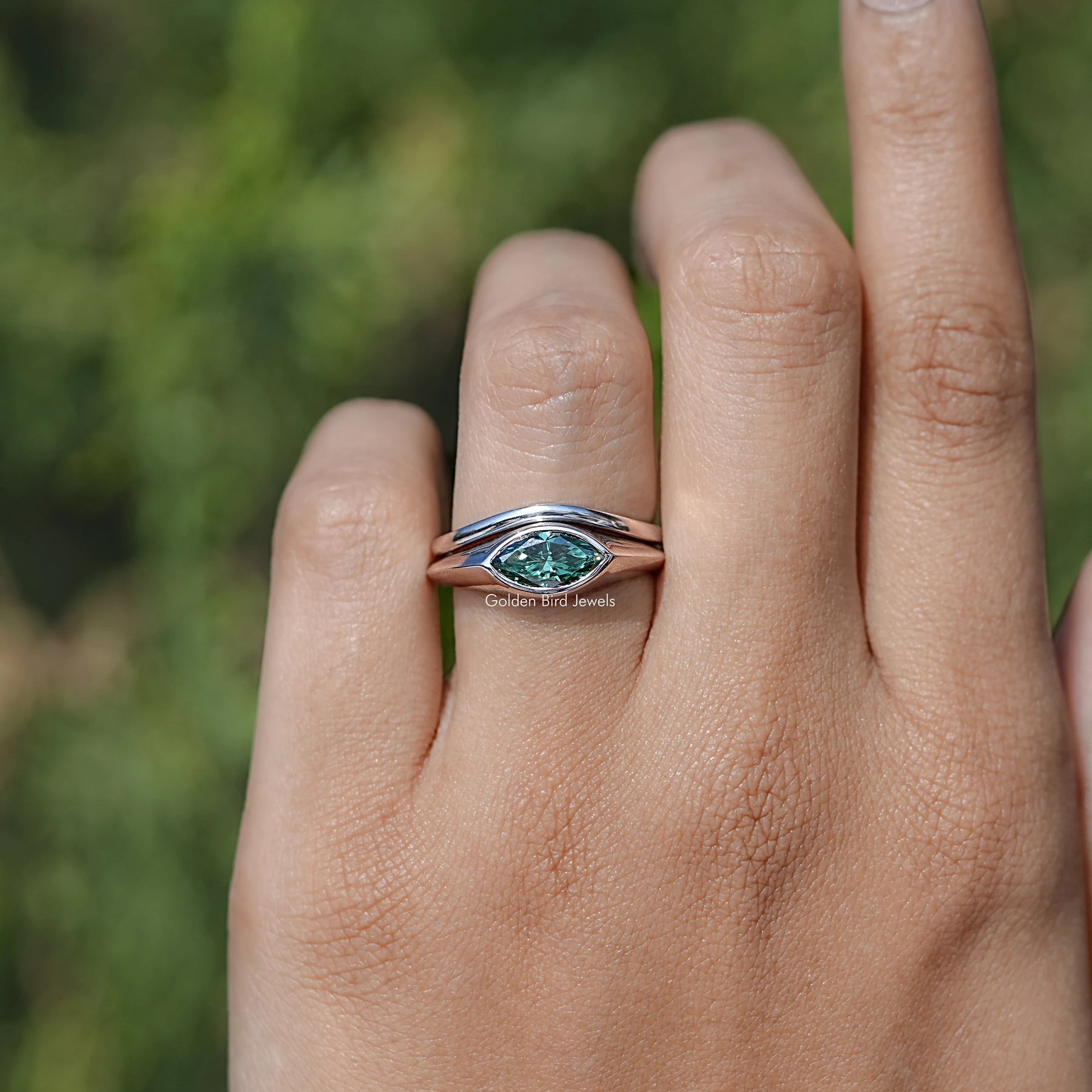 In finger front view of Green Round Cut Moissanite Eternity Band