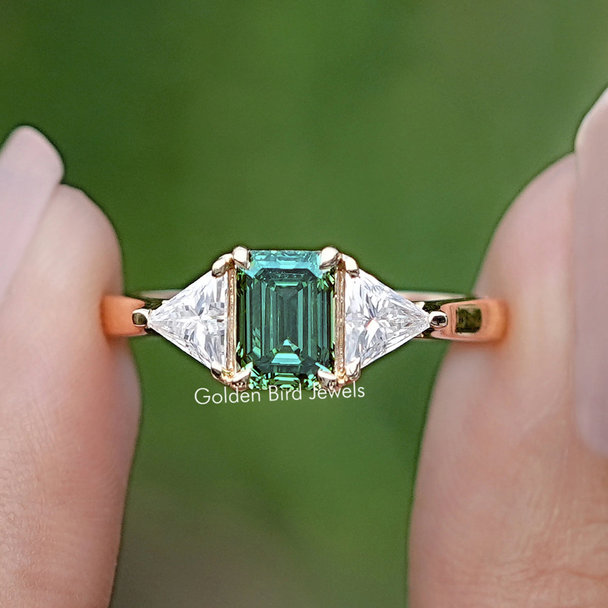 Front view of Emerald And Triangle Moissanite Three Stone Ring