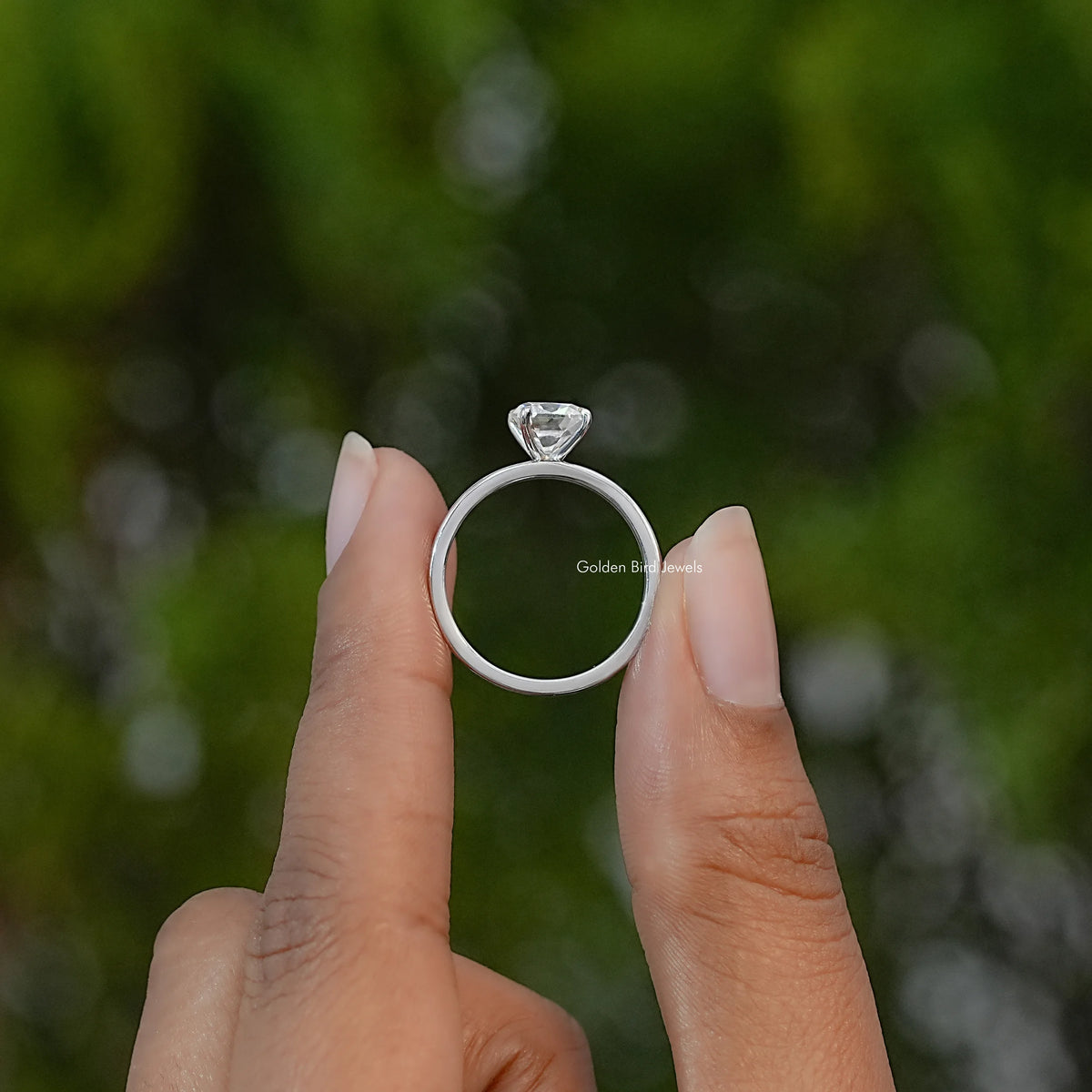 Sterling silver moissanite ring viewed from the side, showing its raised stone and circular band