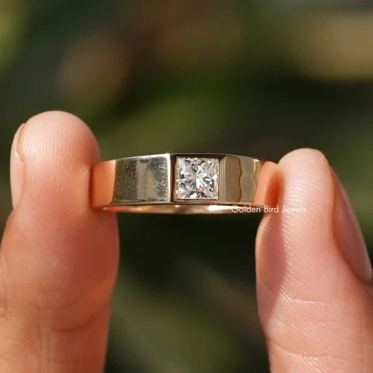 Two fingers holding the Princess Cut Moissanite Solitaire Ring