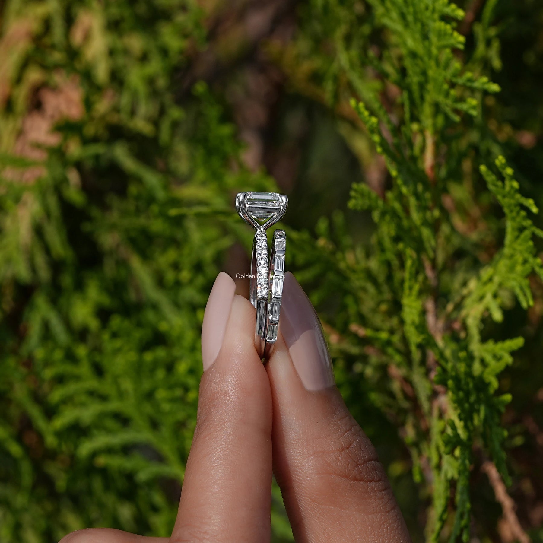Side View A Emerald Cut Diamond Wedding Ring Set in two fingers